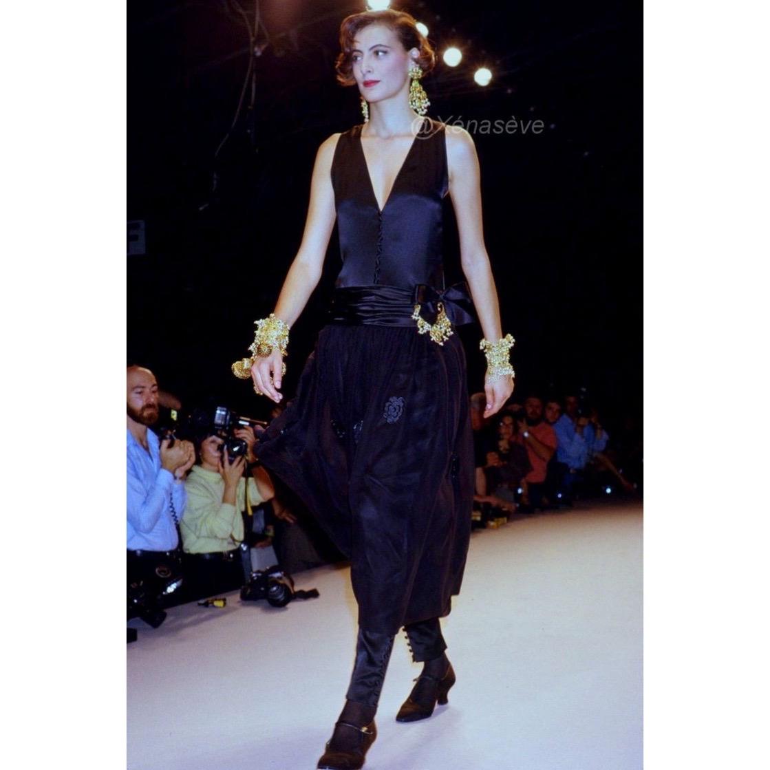 Exquisite and unique, this silk Chanel dress designed by Karl Lagerfeld is a masterpiece from the Spring Summer 1989 collection. Adorned with delicate camellia appliques, the skirt boasts an enchanting elegance as showcased by Ines de la Fressange