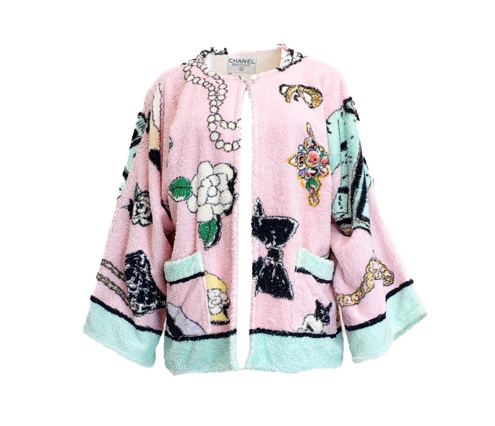 La giacca Chanel primavera 1994 in spugna rosa, indossata da Brandi Quinones, presenta l'iconico bottone in lucite Cornelia Top e una stampa giocosa che la rende un pezzo forte. Progettata per un'eleganza da spiaggia, questa giacca combina la