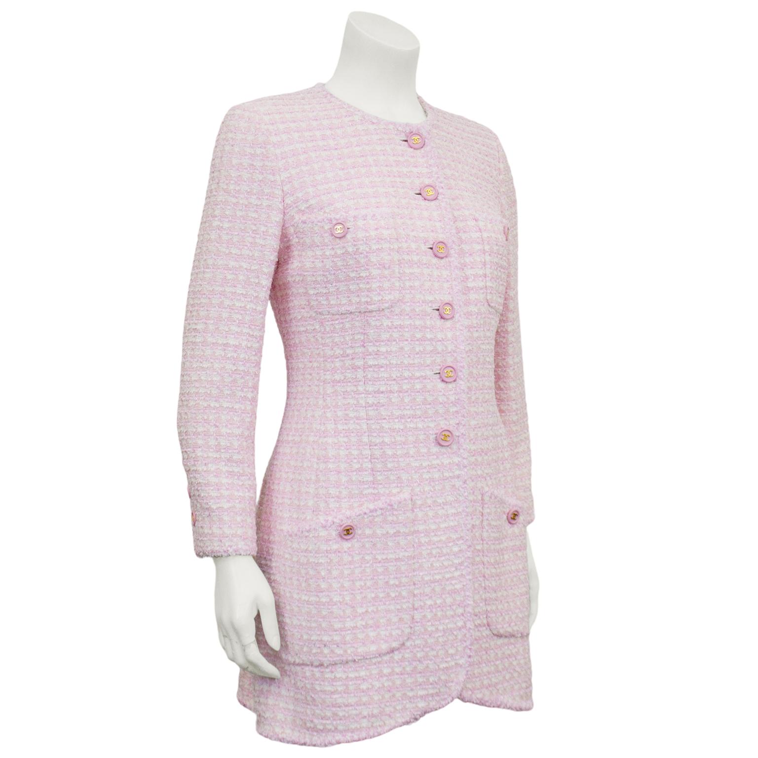 Pale pink and white bouclé jacket from the spring 1998 Chanel collection. Crew neckline, long sleeves, four large patch pockets and tulip hem. Large pink plastic round buttons with gold CC logos down front and at cuffs. White lining. Beautiful shape