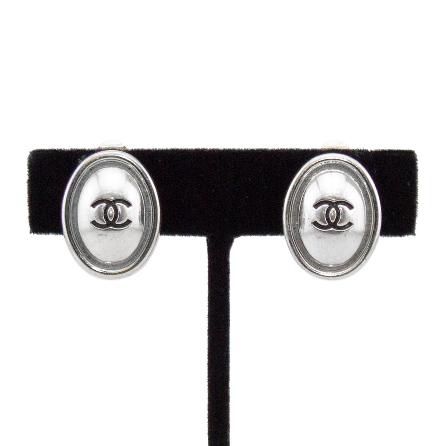 Chanel clip on earrings from the Spring 1999 collection. Silver tone metal oval with engraved interlocking logo in centre. Brand and date plaque on back. The silver is a great alternative to the mostly gold tone Chanel jewelry. Excellent vintage
