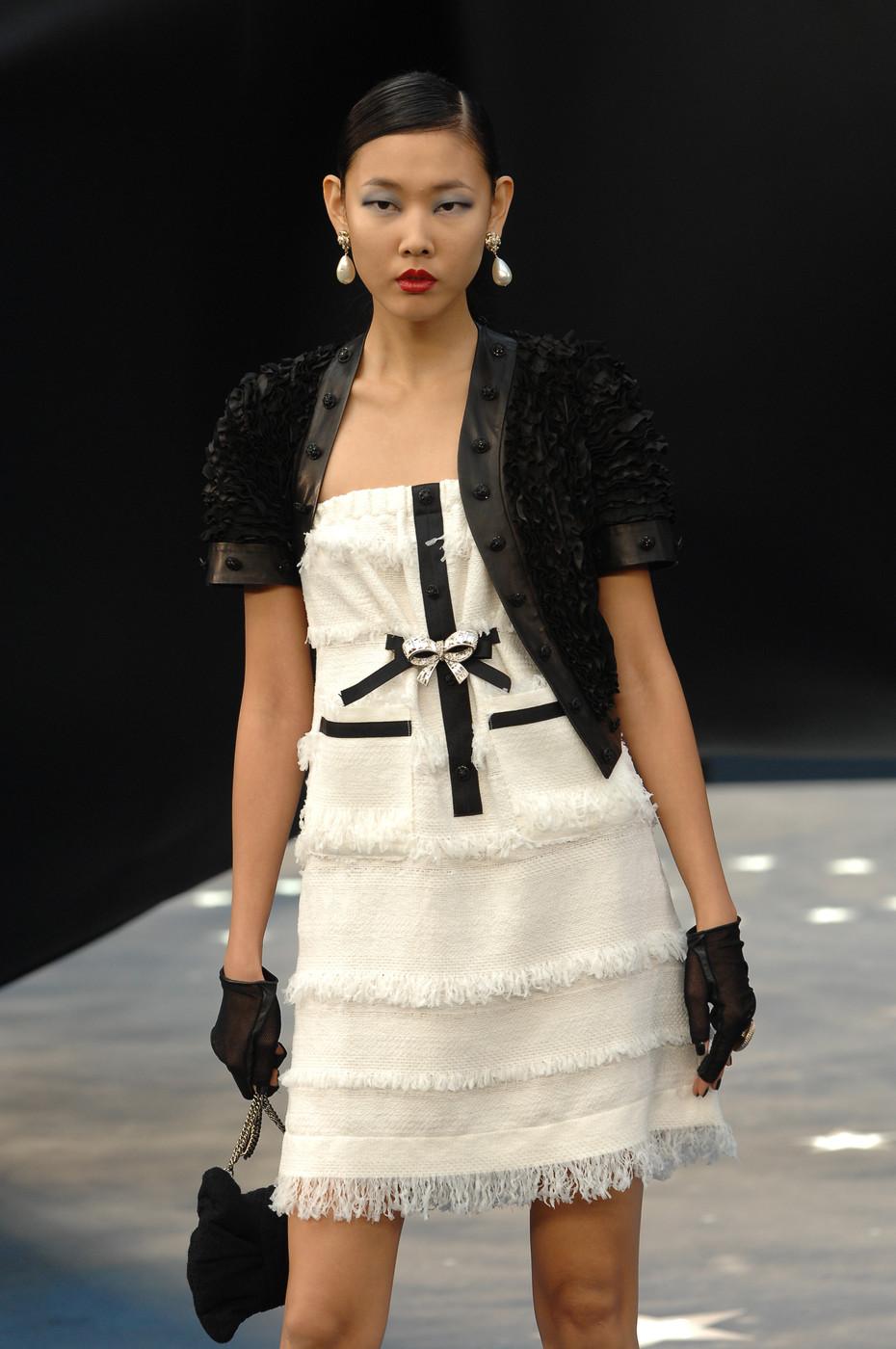 Very sweet Chanel dress from the Spring 2008 collection. White woven wool with layers of horizontal whiteout  fringe. Black satin detail at centre front with small black on black rhinestone buttons with star centers and tiny interlocking CC logos.