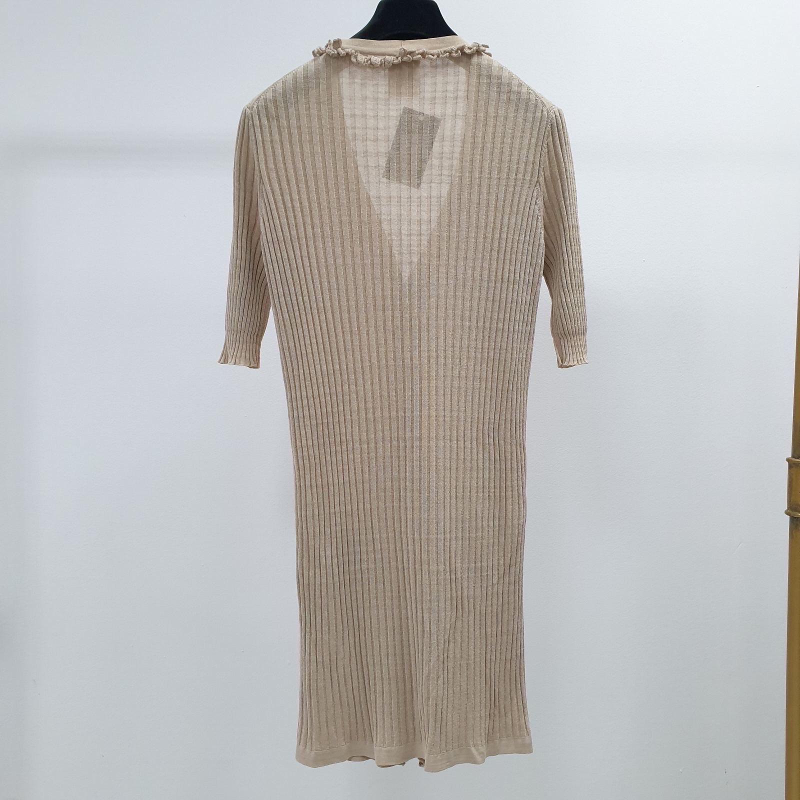 This Chanel cardigan dress is perfect if you want to wear something casual and still look classy. This beautiful ribbed dress is finished with ruffles and gold-toned buttons. It's the perfect addition to your spring closet! 

Material: 

    63%