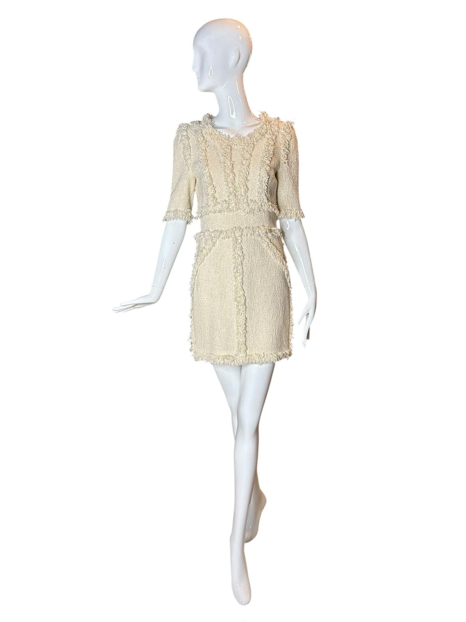 Issue de la collection prêt-à-porter printemps 2010 de Chanel, cette mini robe en bouclette ivoire capture la vision romantique de la campagne de Karl Lagerfeld. Présenté sur le podium, le décor rustique d'une grange souligne la beauté des tweeds