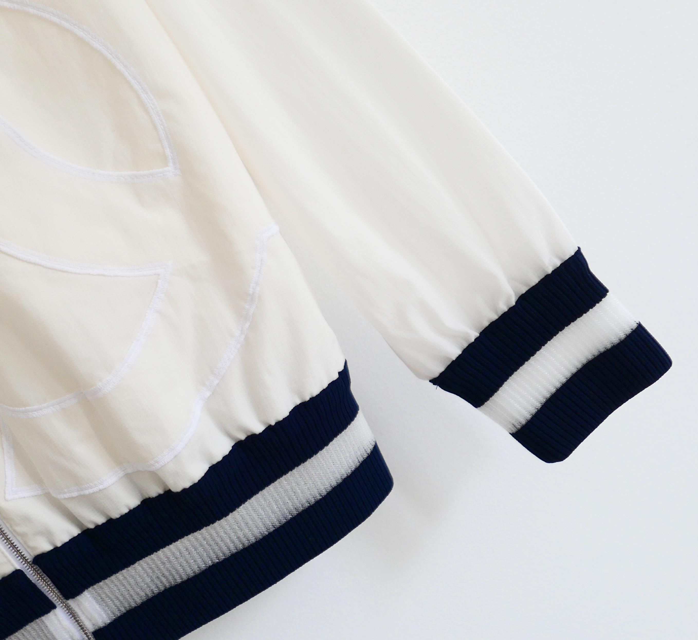 Chaqueta cortavientos Chanel súper chula de la colección Primavera 2018. Sin usar. Confeccionada en suave y crujiente mezcla de poliamida de color crema pálido con ribetes de canalé de viscosa con paneles azul marino y transparentes. Lleva un