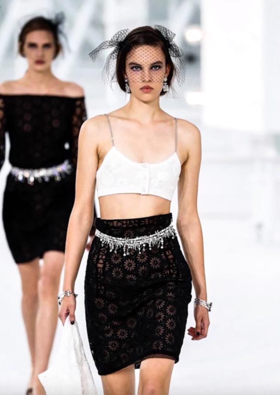 The most wanted white cropped top from Chanel Spring 2021 collection. Sold out worldwide! This sophisticated cashmere top is embellished with sequins, camellia flower motives embroidery, CC logo, pearl buttons and crystal straps. Looks amazing with