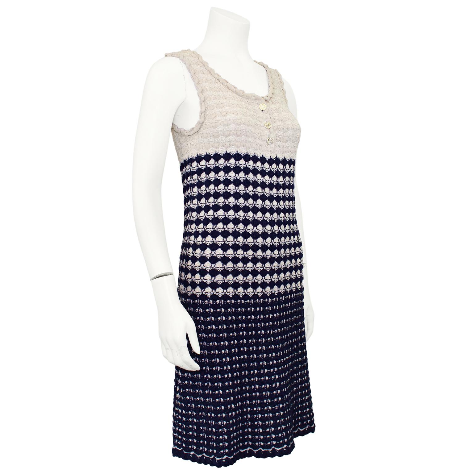 Chic Chanel scallop knit day dress from the Spring/Summer 2012 collection. 40% rayon, 33% cotton, 24% silk, 3% polyester beige and navy blue knit with a twisted trim at the neckline and straps. Sleeveless with a scoop neck and three gold tone metal