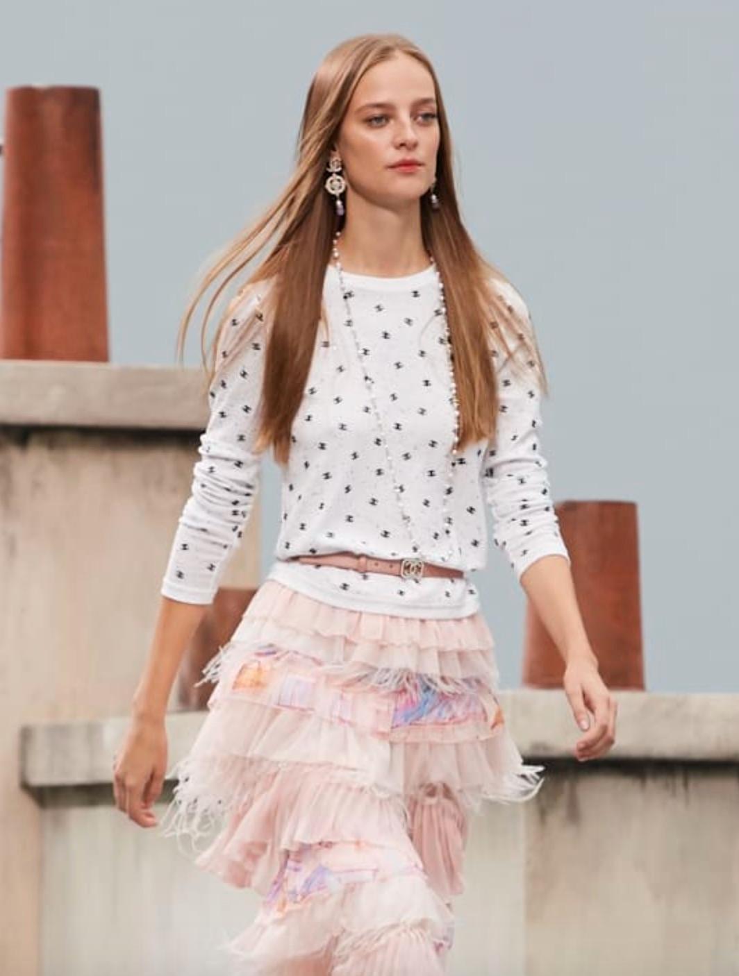This is the highly sought-after long-sleeved cotton top from Chanel's Spring/Summer 2020 collection, featured as runway look #51. It boasts contrasting black CC logo embroidery and a captivating display of multicolored sparkly sequins.
The top is in