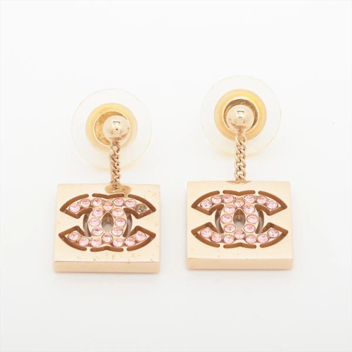 Les boucles d'oreilles pendantes Chanel Square CC Logo Pink Rhinestone sont un accessoire glamour et accrocheur qui allie charme ludique et élégance classique. Réalisées en métal doré, ces boucles d'oreilles sont dotées d'une goutte de forme carrée