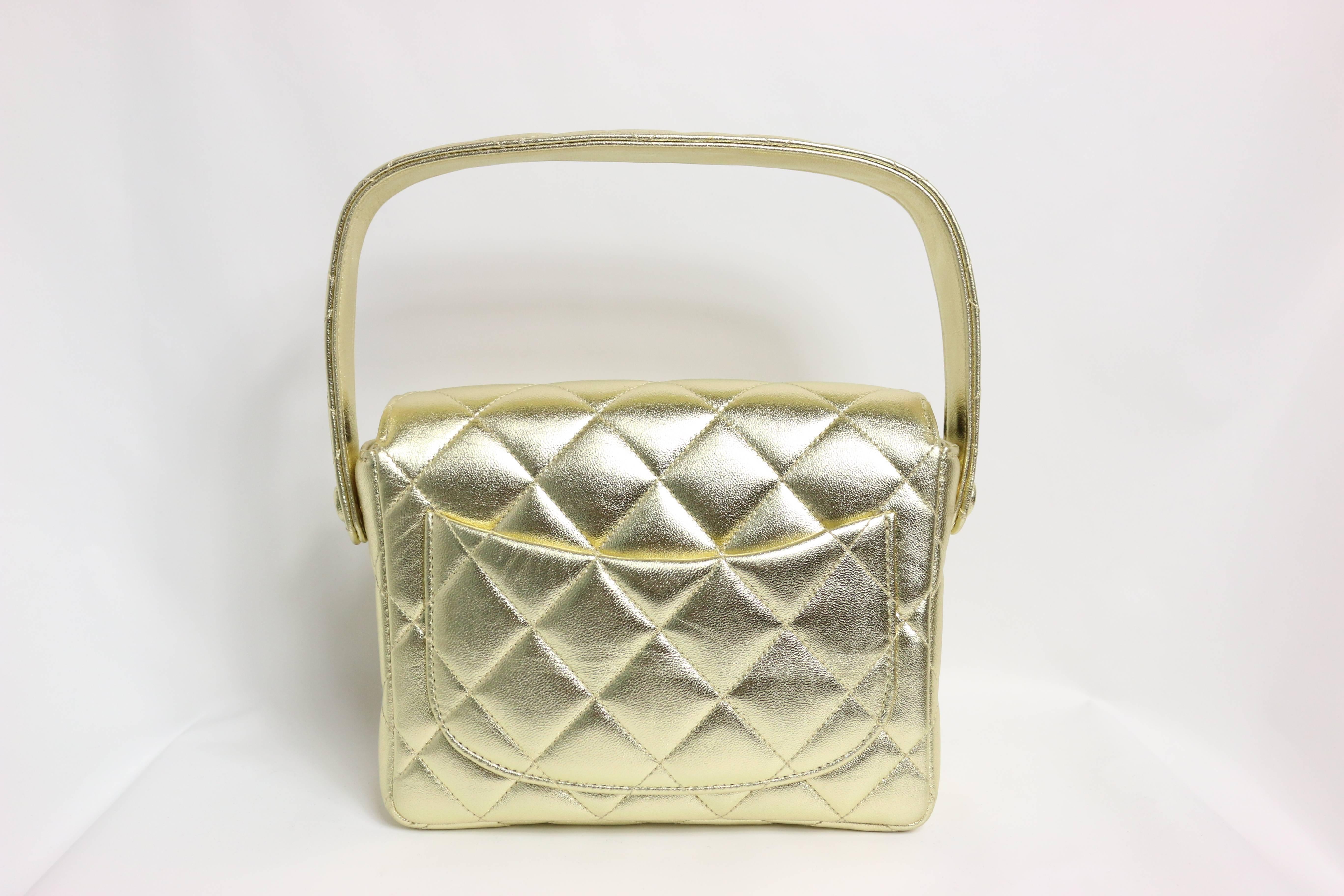 - Chanel square mini gold metallic lambskin leather quilted flap handbag from 1996 to 1997 collection. 

- The interior is lined in a metallic leather

- Height: 5.51 inches / 14 cm
  Width: 6.5 inches / 16.5 cm
  Depth: 1.97 inches / 5 cm
  Handle