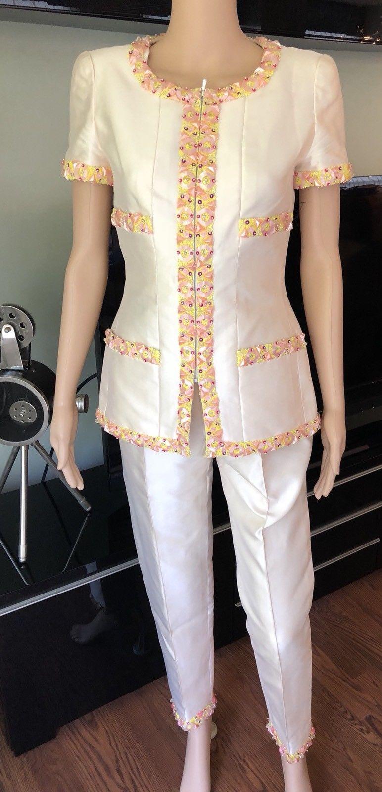 Chanel embellished silk pantsuit. Collarless jacket features bead and sequin embellishment trim throughout, scoop neckline, structured shoulders, short sleeves, four welt pockets at front, silver-tone chain at interior hem and hidden zip closure at
