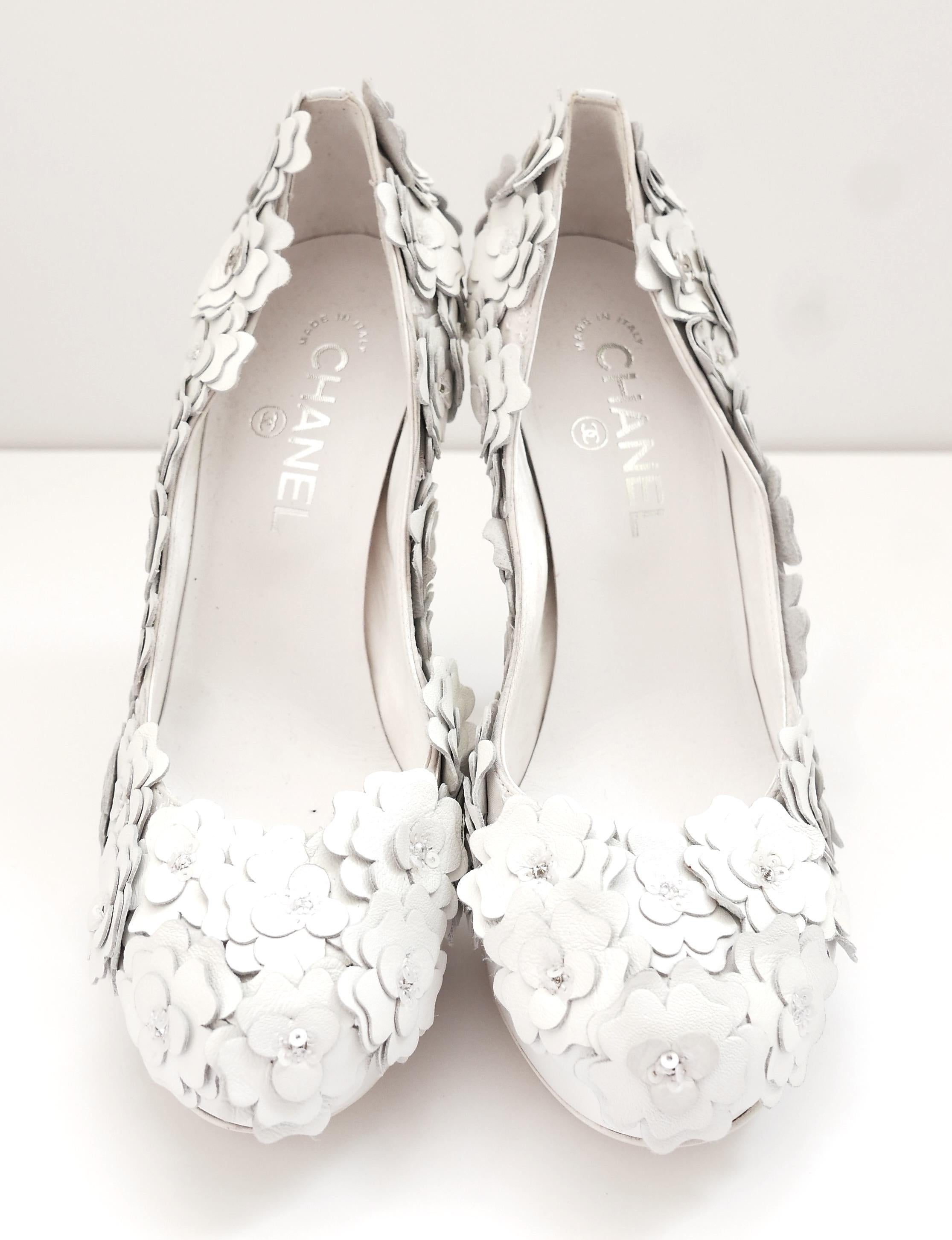 The MOST exquisite, work of art Chanel camellia heels from the Spring 2010 Collection. In unworn condition with dustbag. Collectors’ piece. 
Superbly crafted from thick white leather and satin with the most amazing, 3D, hand sewn leather and sequin