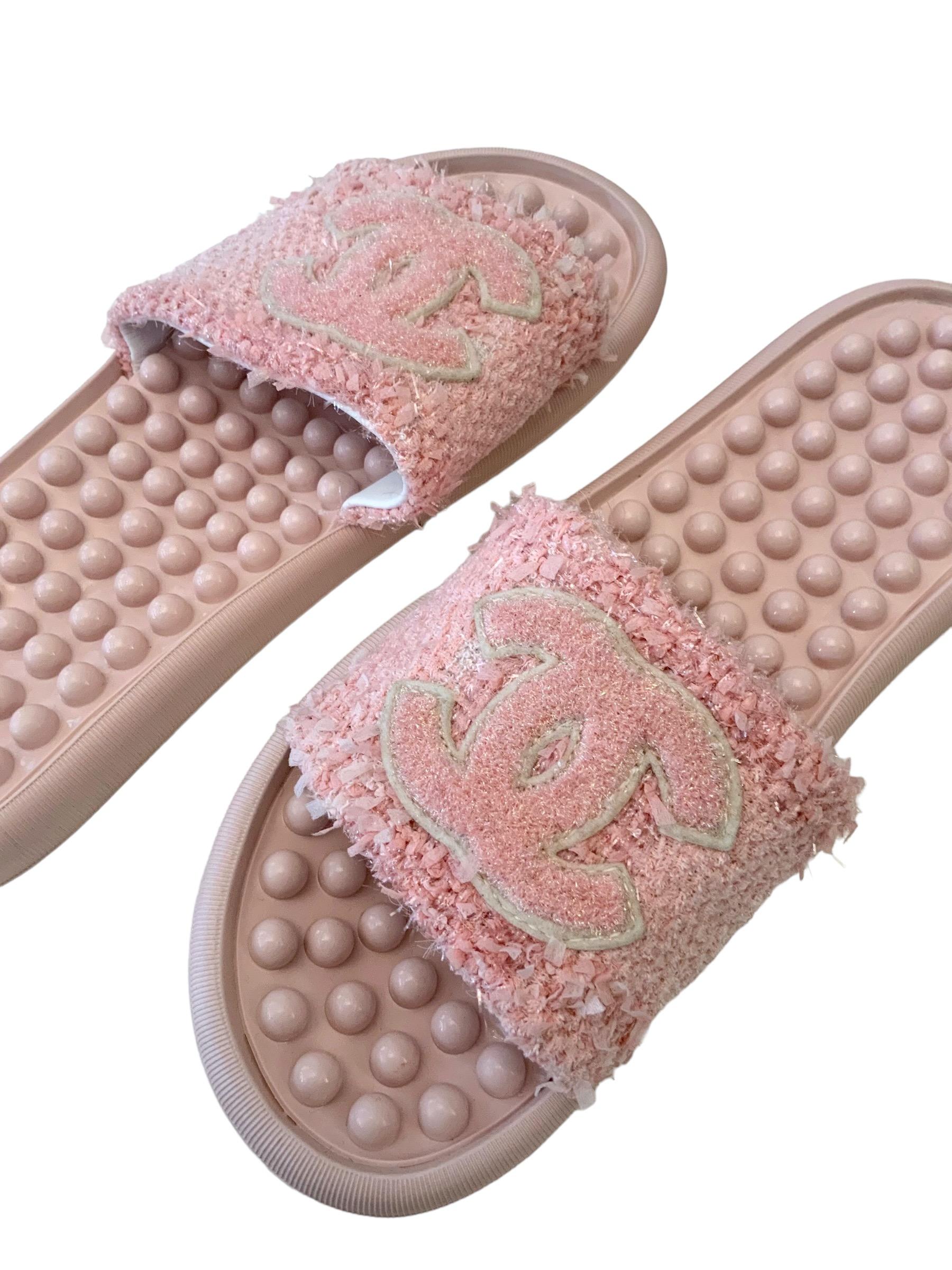 Great slides from the 2018 Spring Summer collection.
Crafted in a pink / coral tweed with a gold thread woven throughout.
It features a CC logo on top and the inside sole is made of small rubber balls to make a great comfort while walking.
To use at