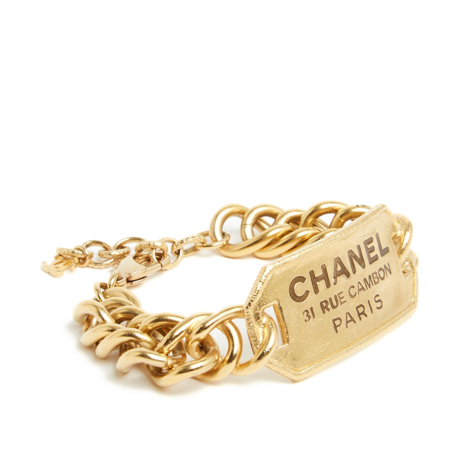 Chanel bracelet SS2020 collection composed of a wide curb chain and a plaque engraved with Chanel and its legendary address, closing with a carabiner on a chain ending with a small CC symbol. Length of the bracelet 17 cm excluding the chain and 21
