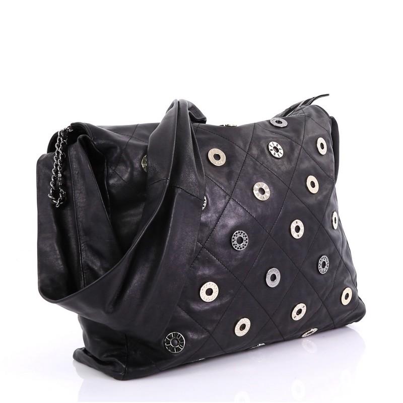 This Chanel Star Attitude Hobo Grommet Embellished Quilted Leather Large, crafted from black quilted leather, features single looped strap, grommet embellishments, and gunmetal and gold-tone hardware. Its zip closure opens to a black fabric interior