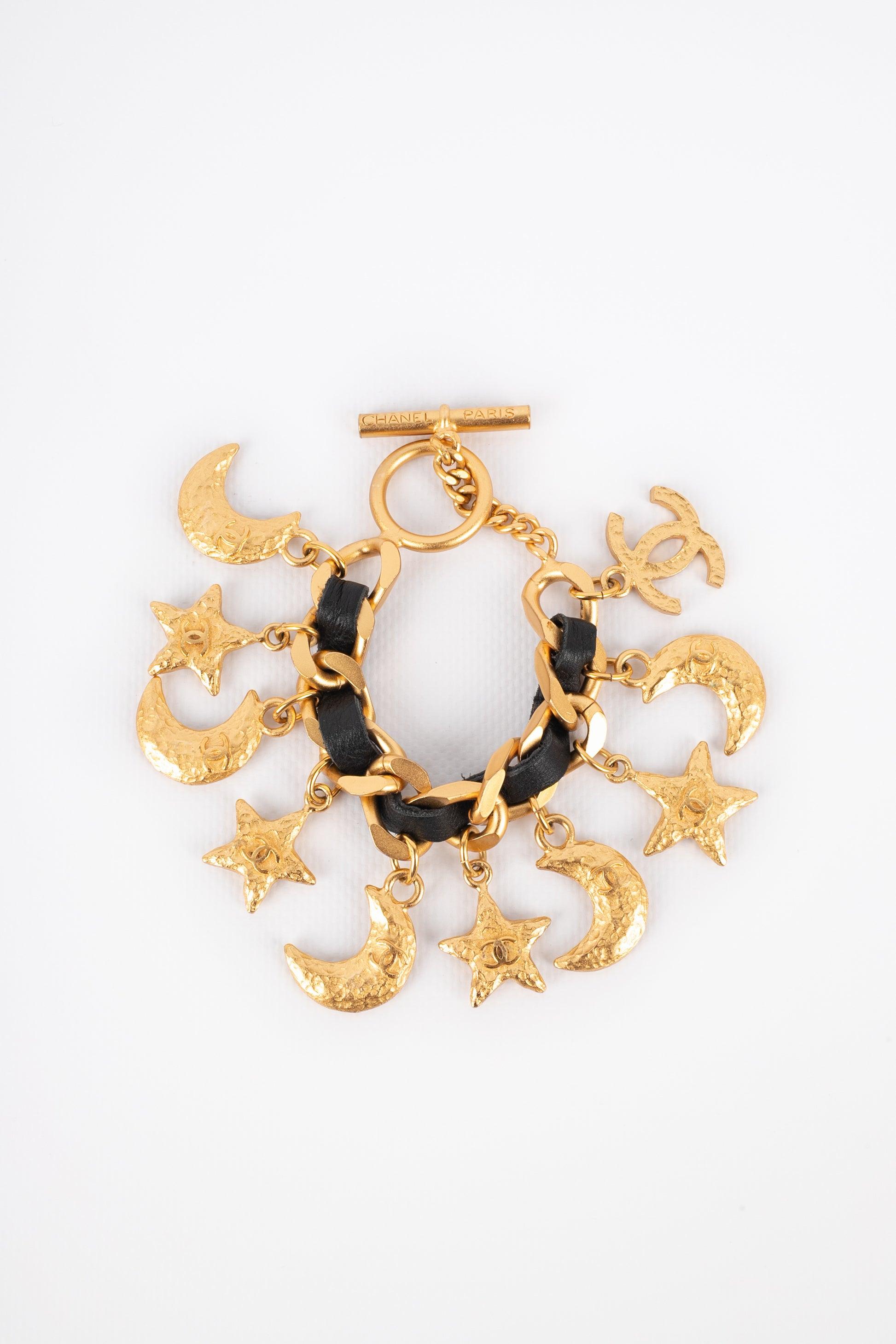 Chanel - (Made in France) Goldenes Metallarmband mit schwarzem Leder und Anhängern, die Sterne und Monde darstellen, zentriert mit cc-Logos. Schmuckstücke mit dem eingravierten S des Verkaufs.
 
Zusätzliche Informationen: 
Zustand: Sehr guter