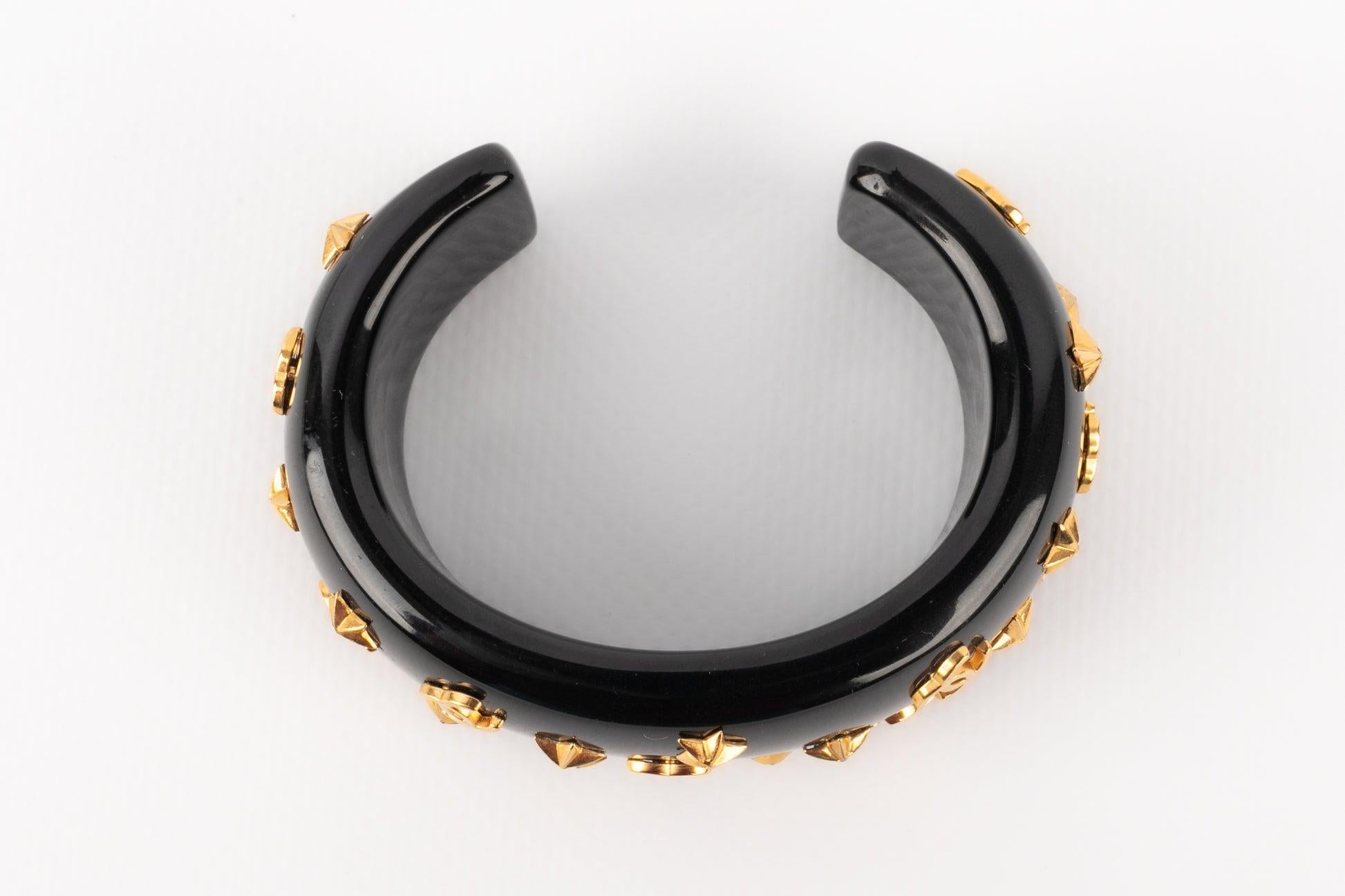 Chanel - (Made in France) Golden metal cuff bracelet with black bakelite. 1995 Fall-Winter Collection.

Additional information:
Condition: Very good condition
Dimensions: Length: 13 cm - Opening: 3 cm
Period: 20th Century

Seller Reference: BRAB25
