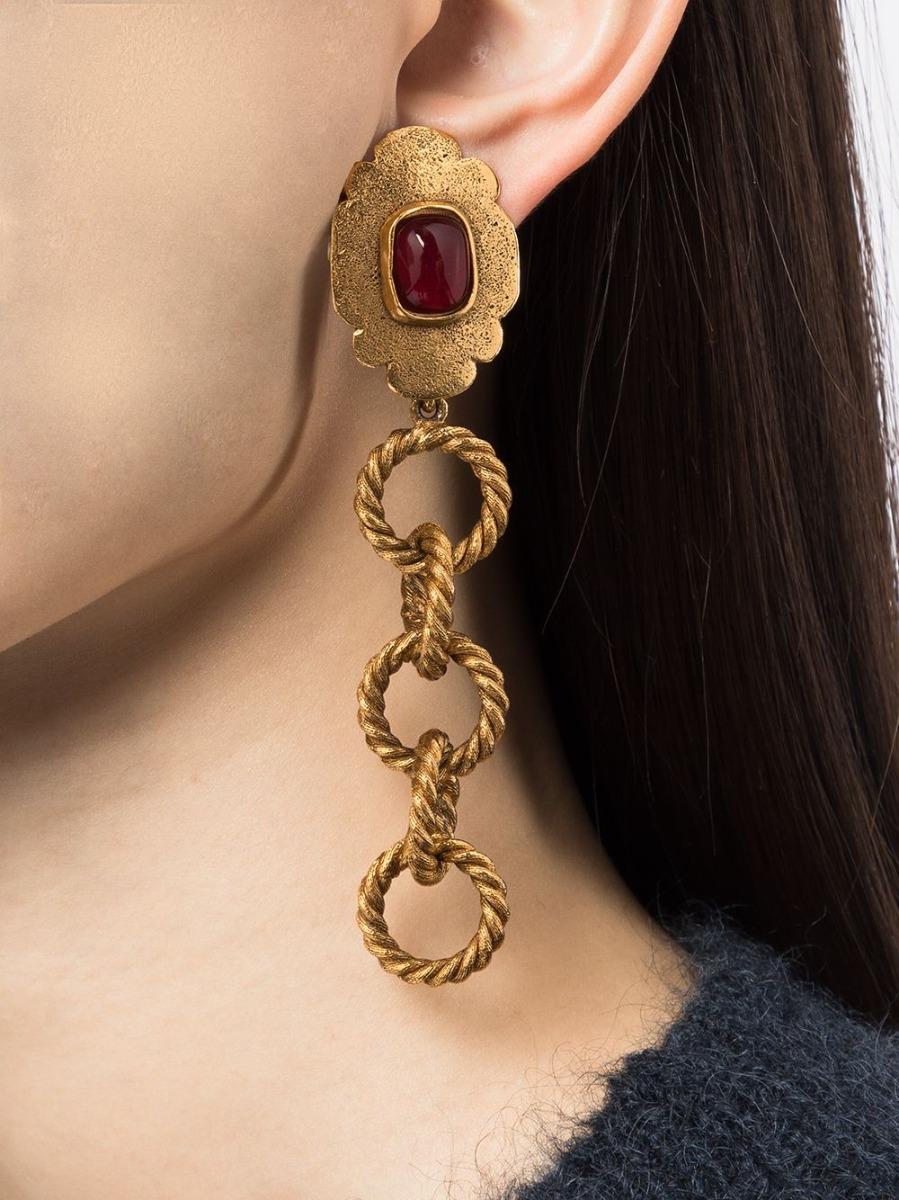 The luxurious creation of Maison Gripoix exclusively for Chanel, are clip-on 1980s vintage Chanel earrings boast a large central ruby red stone in Gripoix glass set on a gold-toned base with oversized chainlink embellishment. Pair these statement