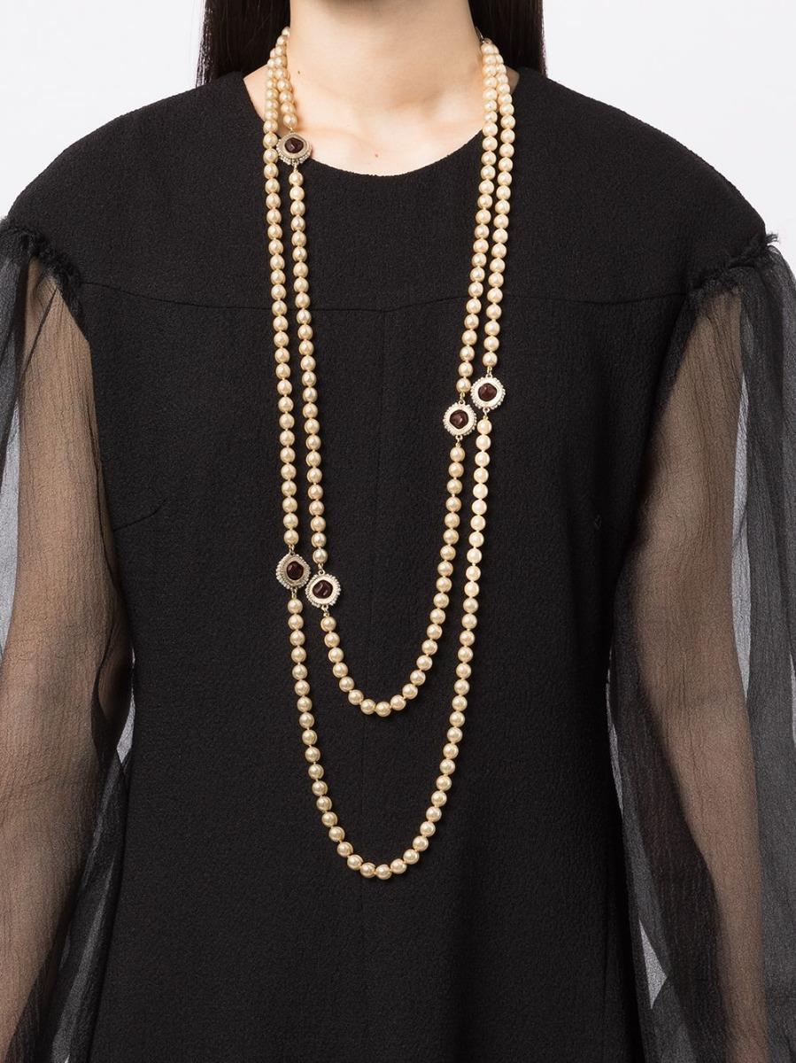 A creation of Maison Gripoix for Chanel, this stunning pre-owned boasts a strand of faux pearls finished with three ruby red glass poured gems 
surrounded by gold-toned metal embellished with small faux pearls, this necklace can be fastened using a