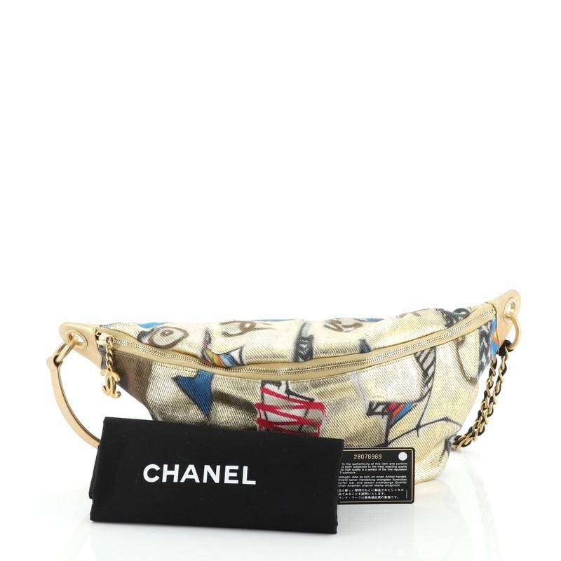 This Chanel Street Spirit Waist Bag Printed Canvas, crafted in gold and multicolor quilted canvas, features woven in fabric chain and leather strap, graffiti print, and gold-tone hardware. Its zip closure opens to a red fabric interior with zip