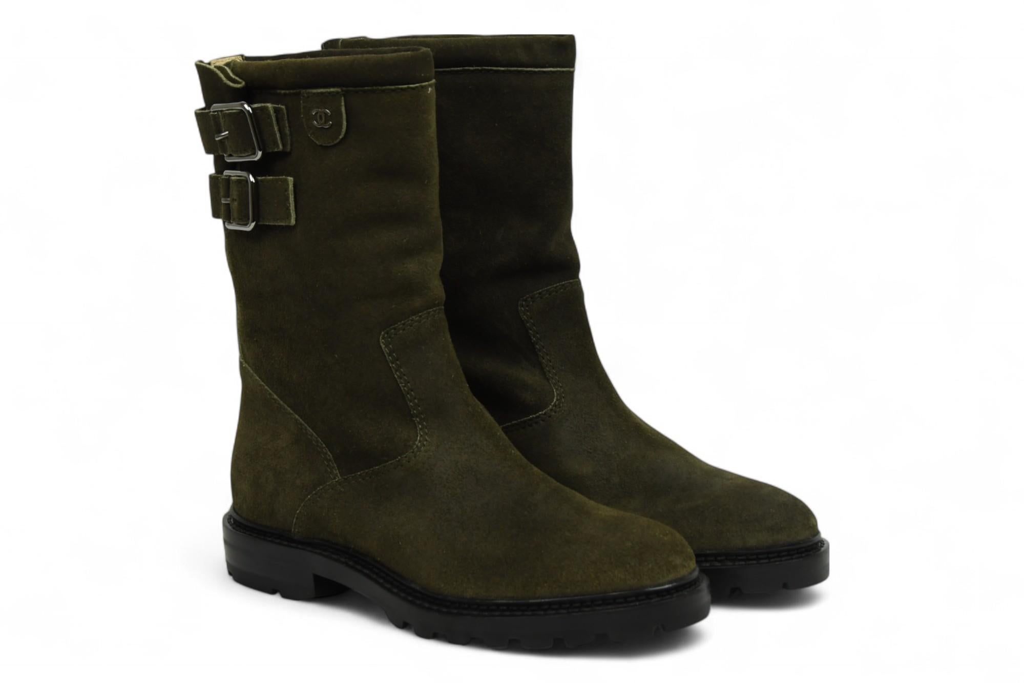 El lujo duro se une a la elegancia atemporal de Chanel en estas Botas Chanel a media pierna de ante verde oliva. Confeccionada en ante afelpado en un intenso tono oliva, esta silueta inspirada en las motos se eleva con la sofisticación