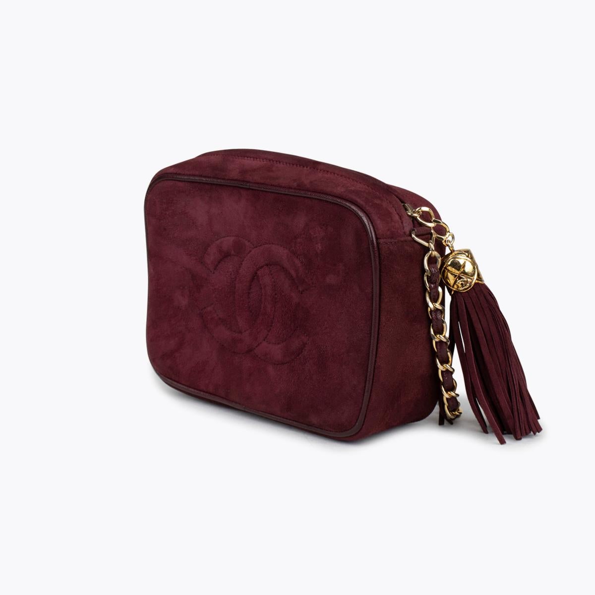 Burgundy suede vintage Chanel Camera bag with

– Gold-tone hardware
– Single chain-link and leather shoulder strap
– Tonal leather trim
– Debossed CC logo accent at exterior front and back, tonal leather lining, single zip pocket at interior wall