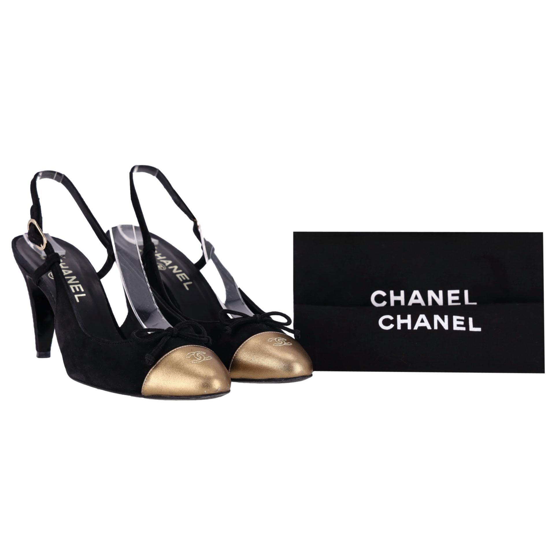 We Adore - Escarpins en daim Chanel avec bout pointu orné du logo 'CC' métallique

Talons en daim noir ornés d'un bout en cuir métallisé doré, détaillés avec les surpiqûres du logo 'CAP' et un nœud noir.

Elles sont dotées d'un design sling-back,
