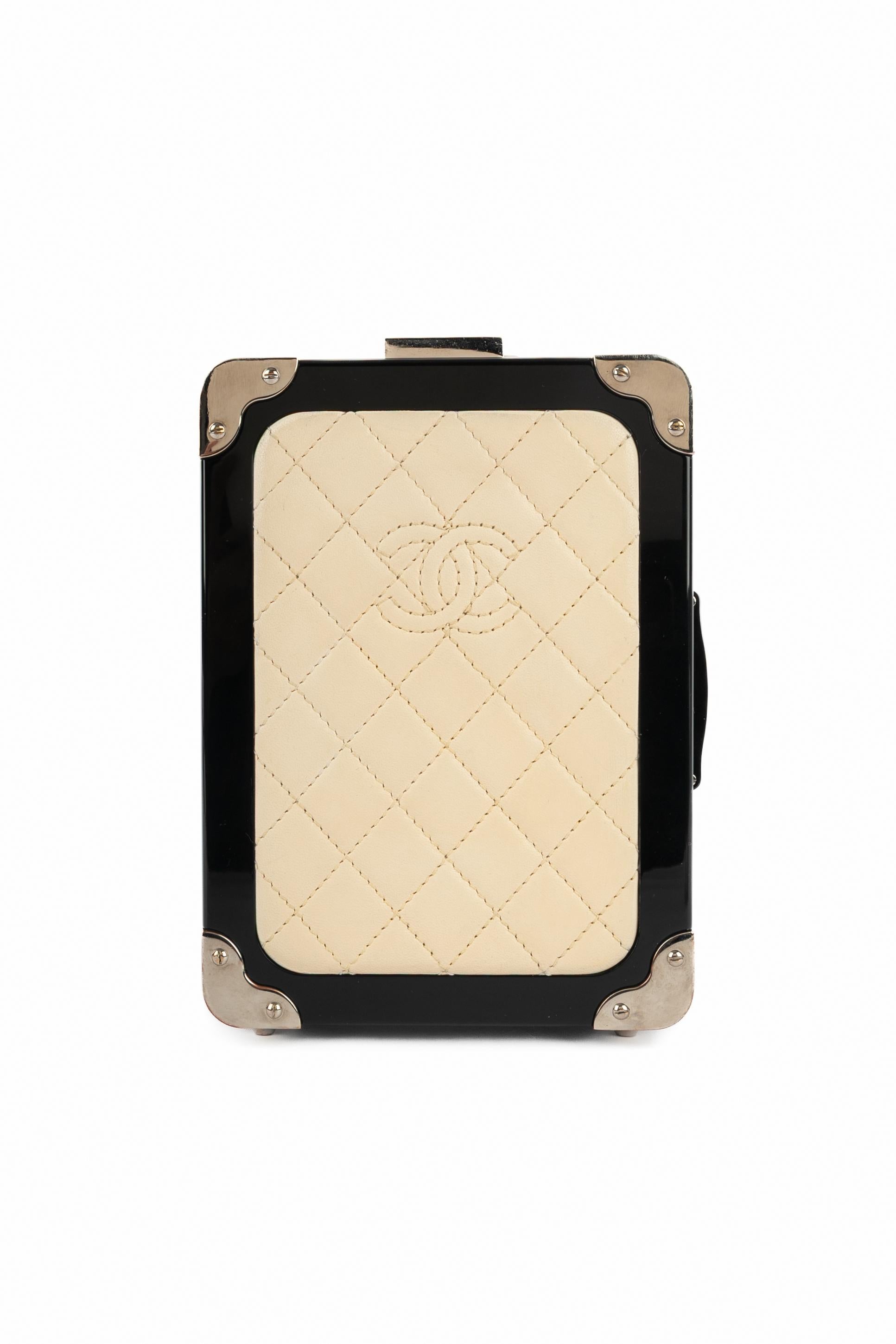 CHANEL - (Made in Italy) Black lucite and silvery metal 'Suitcase' minaudiere bag with a quilted beige lamb leather front, and a silvery metal chain handle. Piece with a serial number. 2016 Spring-Summer Airlines Collection under the artistic