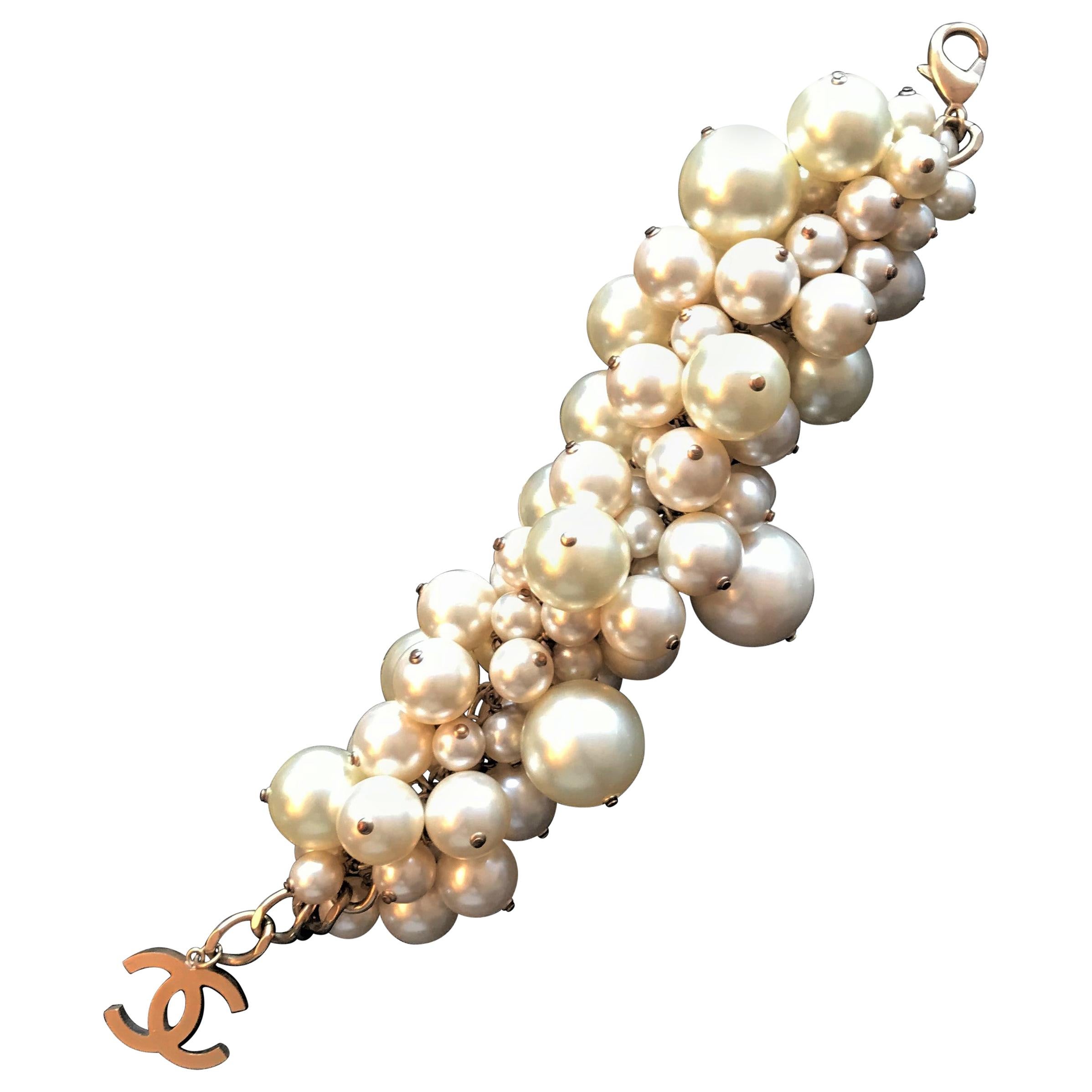 A large lush bombastic pearl bracelet from Chanel with attached CC clasp from the summer collection 2013. 
A very decorative imitations pearl bracelet  of different sizes. These are all attached to a central metal chain. This piece was featured 2013