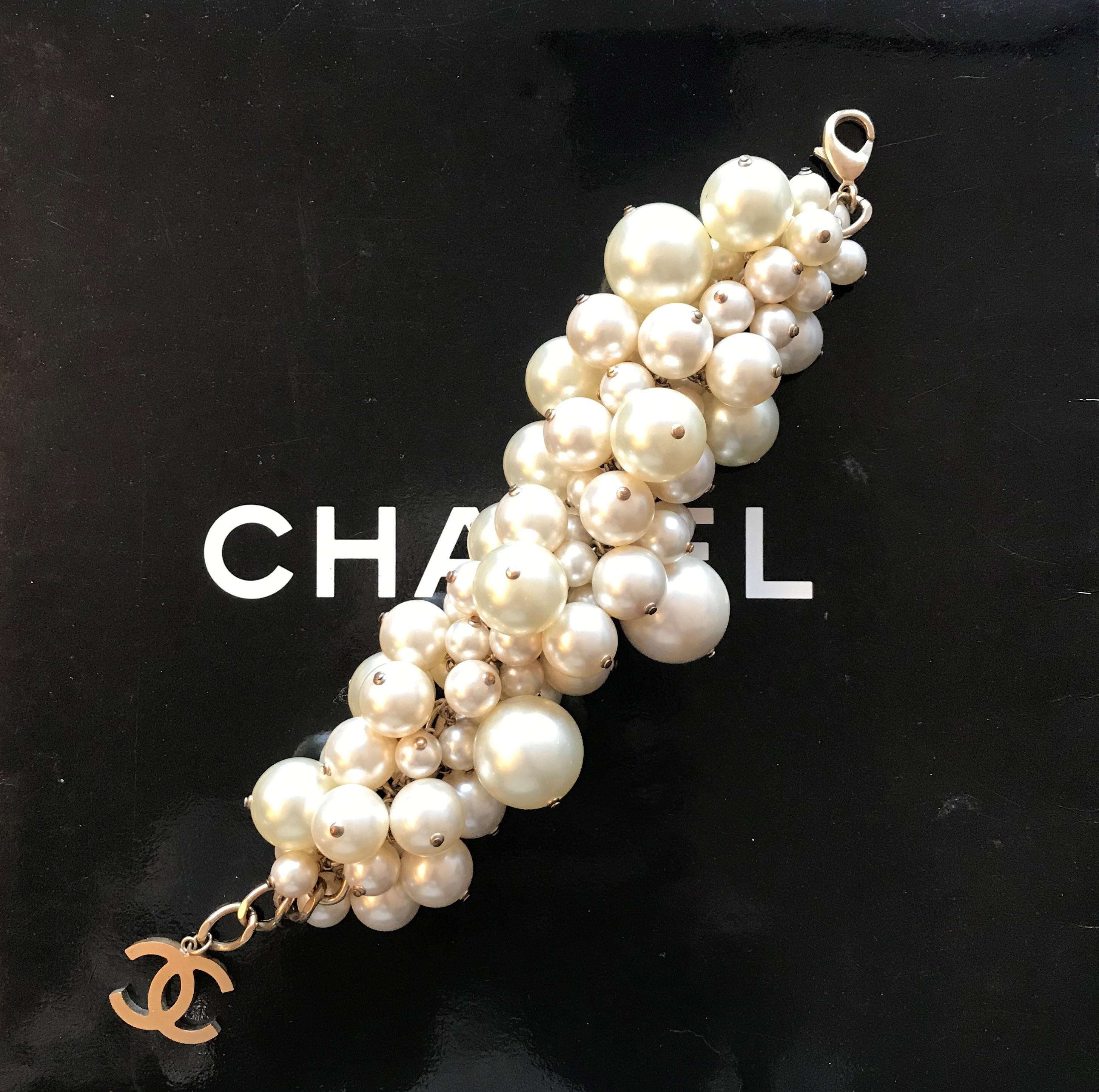 A large lush bombastic pearl bracelet from Chanel with attached CC clasp from the summer collection 2013. 
A very decorative imitations pearl bracelet  of different sizes. These are all attached to a central metal chain. This piece was featured 2013