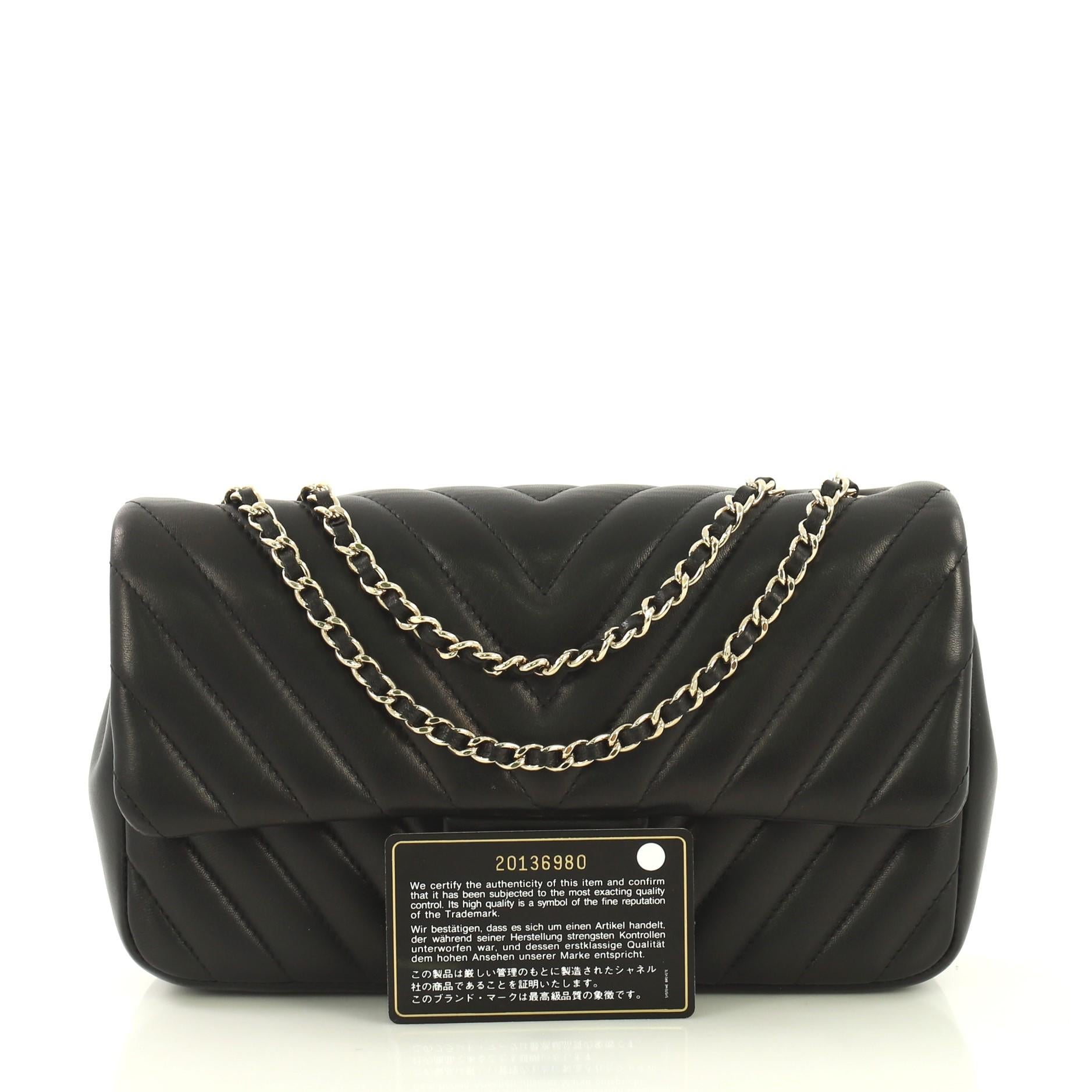 This Chanel Surpique CC Flap Bag Chevron Lambskin Medium, crafted in black chevron lambskin leather, features woven in leather chain link strap and gold-tone hardware. Its CC turn-lock closure opens to a maroon leather interior with side zip and
