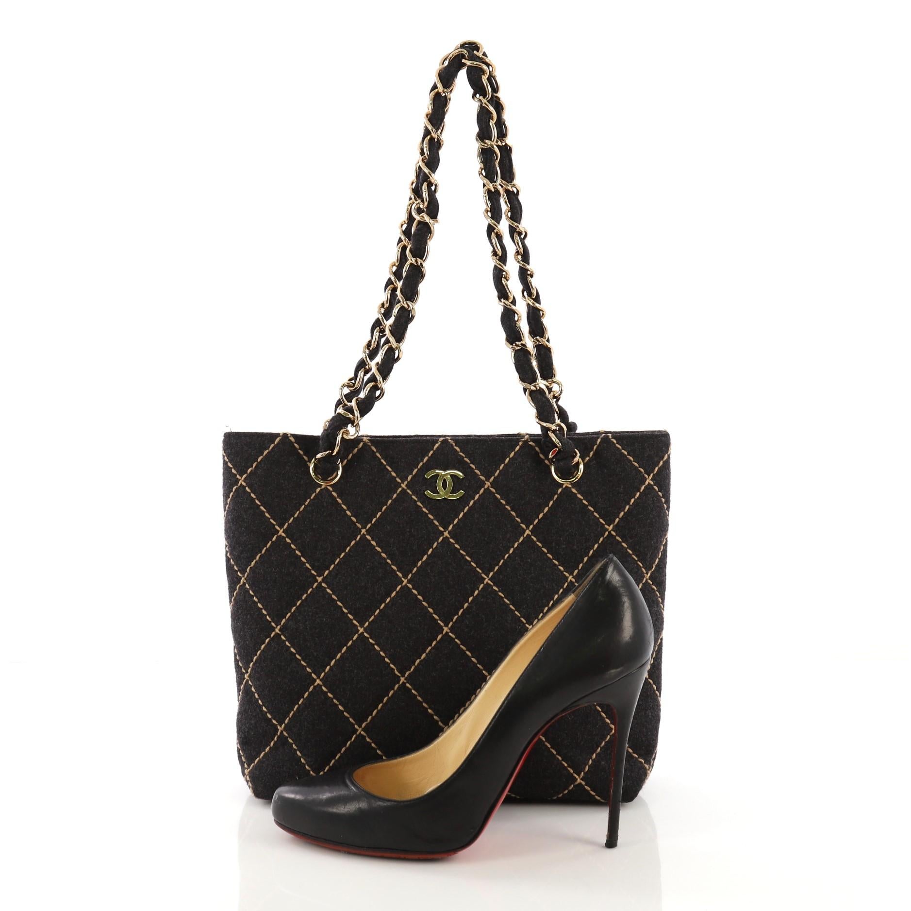 This Chanel Surpique Chain Tote Quilted Wool Small, crafted in dark gray quilted wool, features woven in wool chain link straps and gold-tone hardware. Its magnetic snap closure opens to a black fabric interior with side zip and slip pockets.