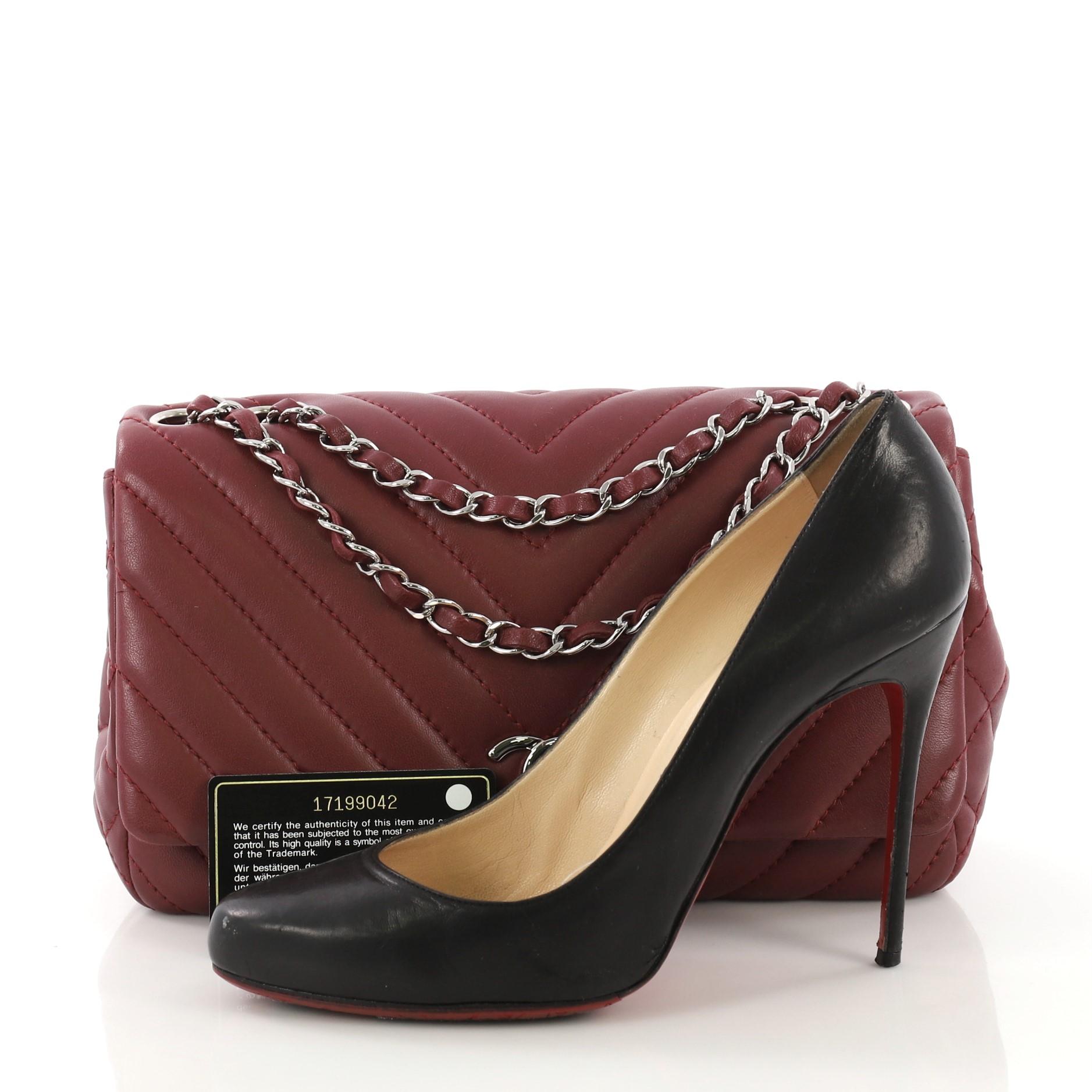This Chanel Surpique Chevron Chain Flap Bag Quilted Lambskin Medium, crafted in burgundy quilted lambskin leather, features woven in leather chain link strap and silver-tone hardware. Its CC turn-lock closure opens to a burgundy fabric interior with
