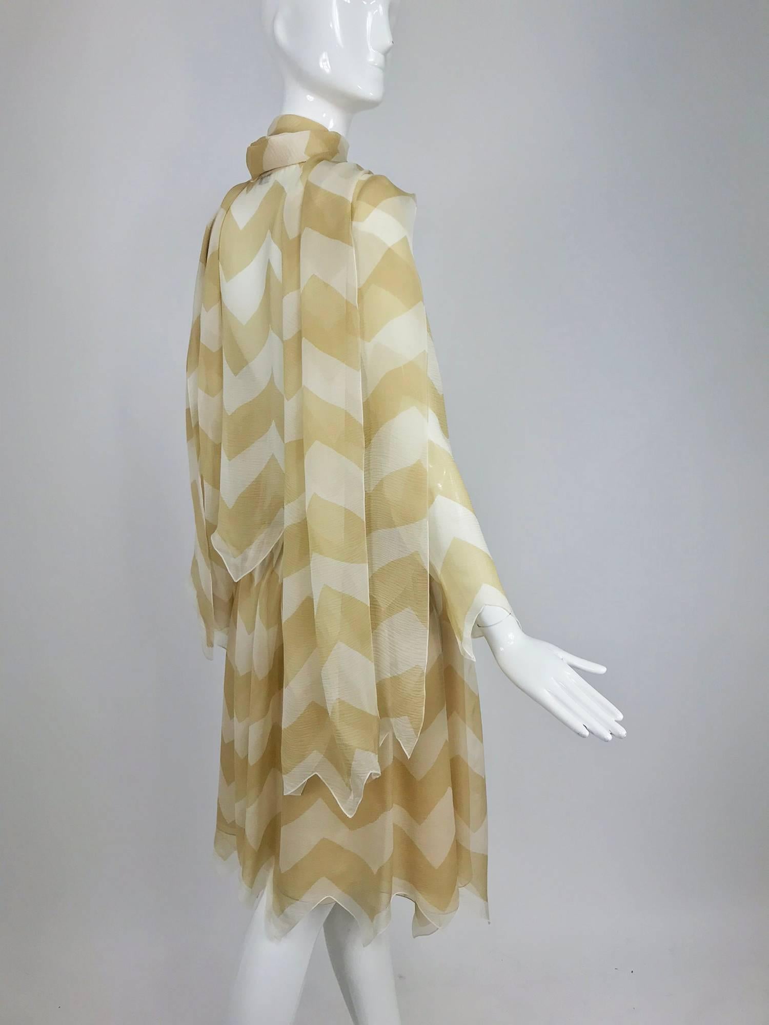 Chanel tan and cream silk chiffon zig zag pattern blouse and skirt 2000A...Sheer blouse is unlined, long sleeves with zig zag cuffs...Blouse buttons at the front with mother of pearl buttons, long and wide attached neck ties, will work as a shawl or