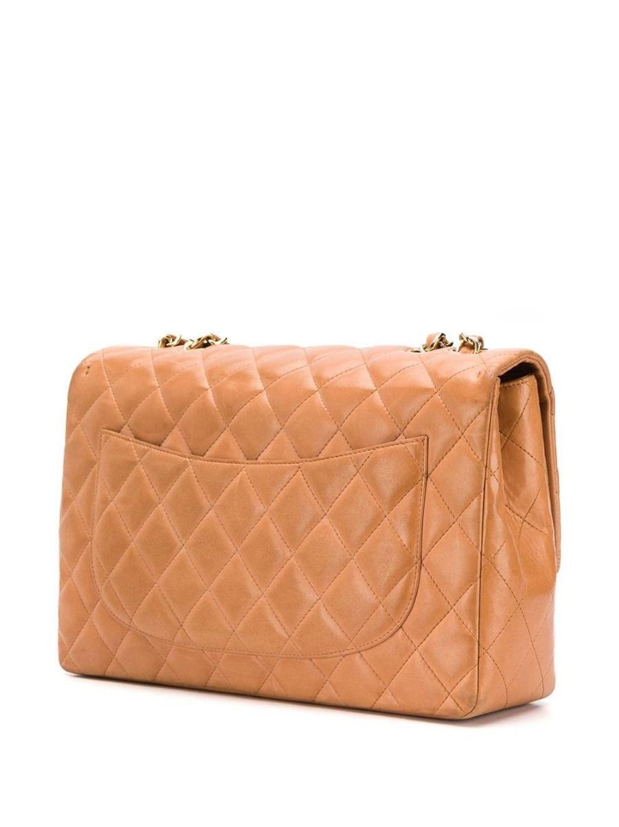 Crafted in Italy from luxurious tan-coloured lambskin leather, this timeless pre-loved Chanel jumbo flap bag features a diamond quilted finish, a back slip pocket and the iconic interlocking CC logo stitched decoratively onto the front flap pocket