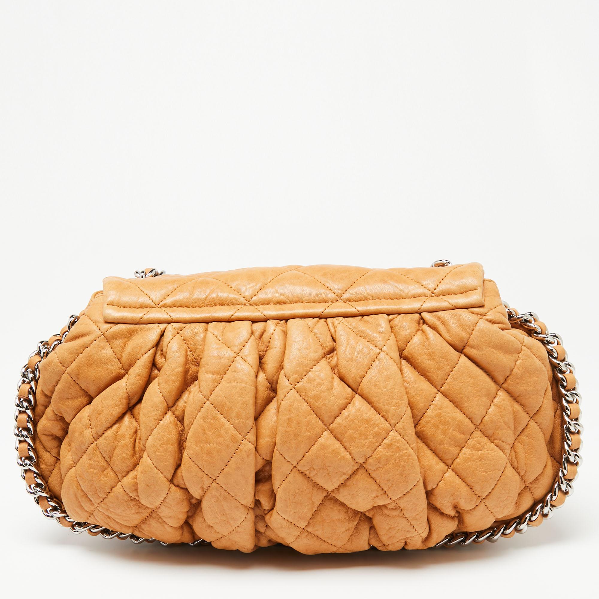 This shoulder bag from Chanel is perfect for your fashion arsenal, bringing along the iconic quilt pattern, the CC logo on the flap, and a woven chain trim outlining the bag and also forming the shoulder strap. It is finely crafted from tan leather