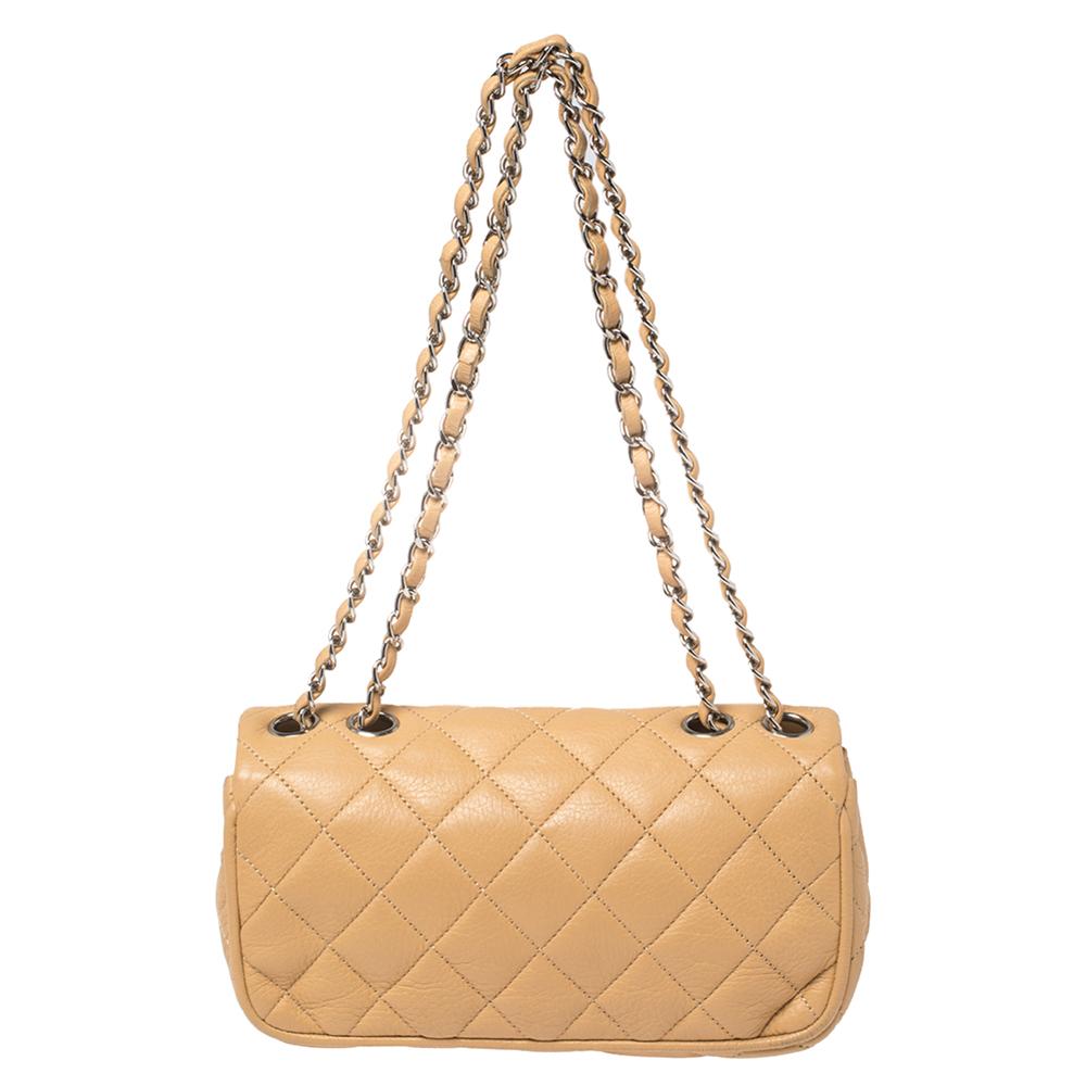 This beautifully fashioned bag will surely be a favorite in your closet. Crafted in a quilted style using tan leather, this East West Flap bag is equipped with a woven chain link and a well-sized nylon interior. You are sure to love this timeless