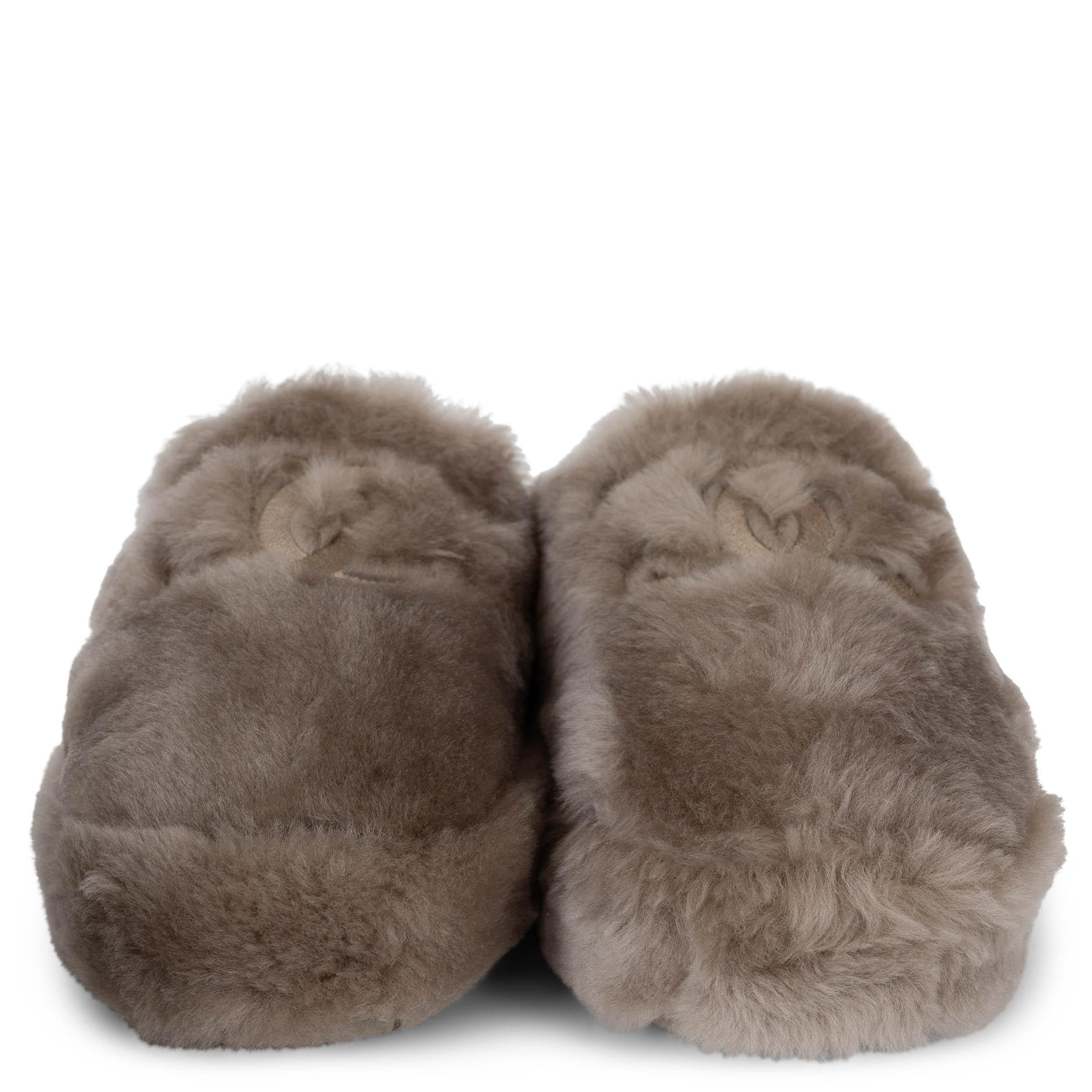 Diese 100% authentischen Chanel taupefarbenen Shearling-Logo-Slipper sind die perfekte Mischung aus Luxus und Komfort. Sie sind aus plüschigem Shearling mit CC-Logo-Nähten gefertigt und bieten kuschelige Wärme mit einem schicken Chanel Touch. Die