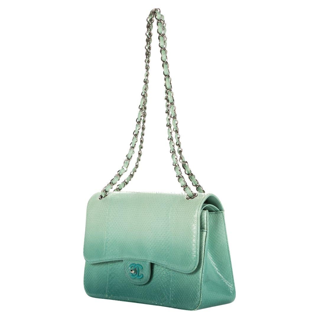 Chanel's 2015 Jumbo Ombre bag in teal python is a statement piece with its iconic silver-tone CC turnlock, opening to a leather interior with a zippered pocket and two slip pockets.

SPECIFICS
Length: 12.2