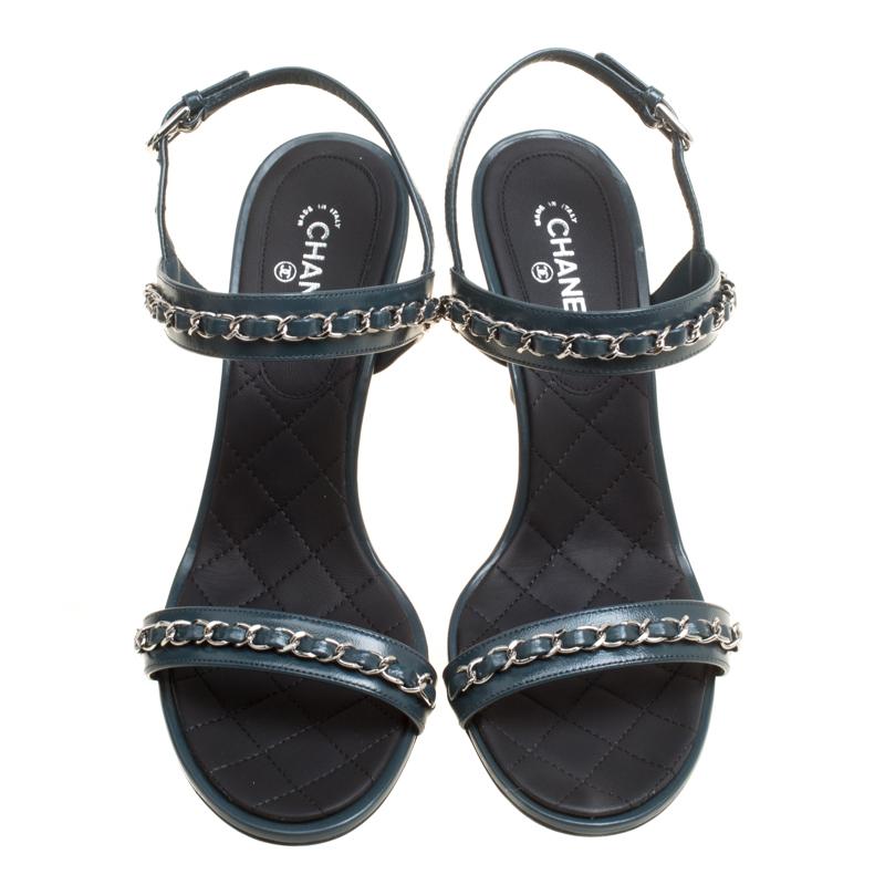 Bring in the subtle glamour to your outfits with this pair of sandals from Chanel. They have been crafted from teal blue leather and styled with slender straps at the front and ankles both accented with interwoven chain details. These sandals come