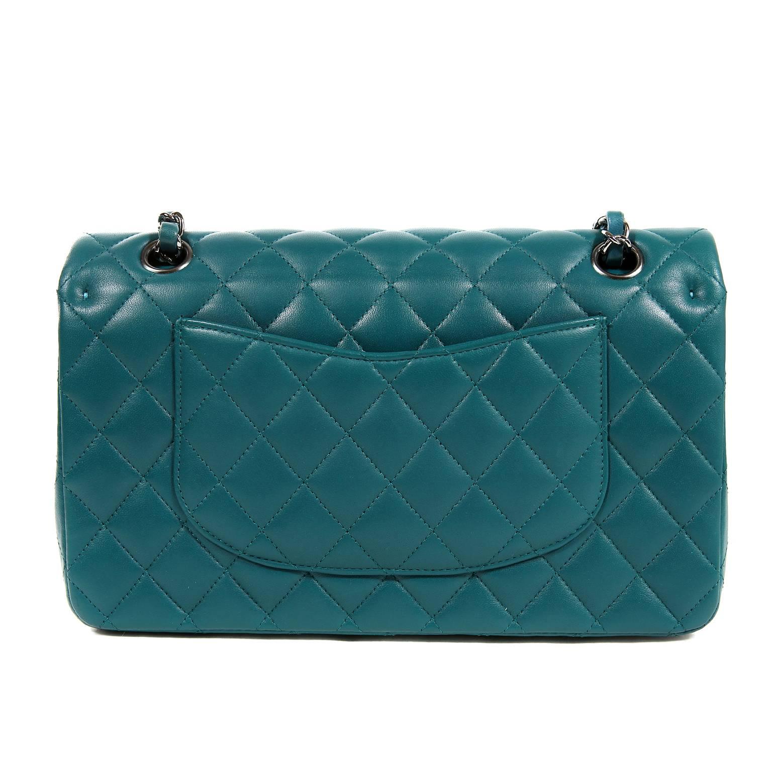 Chanel Teal Lambskin Medium Classic Flap Bag-  PRISTINE; it is unworn and never before carried. A beautiful bold color, teal with silver hardware is very striking. 
Jewel toned teal lambskin is quilted in signature Chanel diamond pattern.  Silver