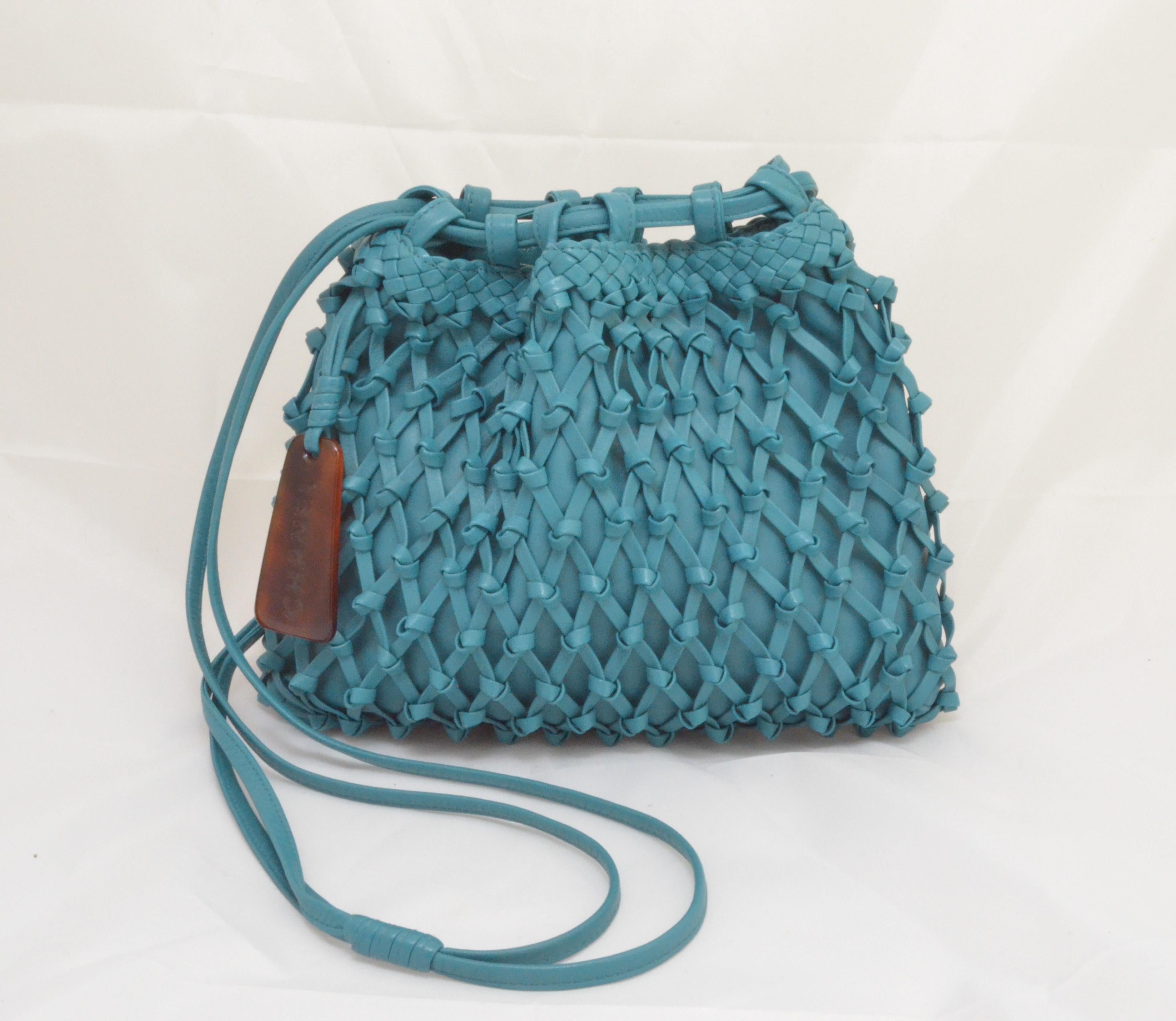 Chanel bag is featured in a teal-colored knotted leather with a tortoise and leather charm that hangs off the side of the bag, and dual leather strap handles. Interior is fully lined in leather and has one zipper pocket. Made in Italy.

Very good