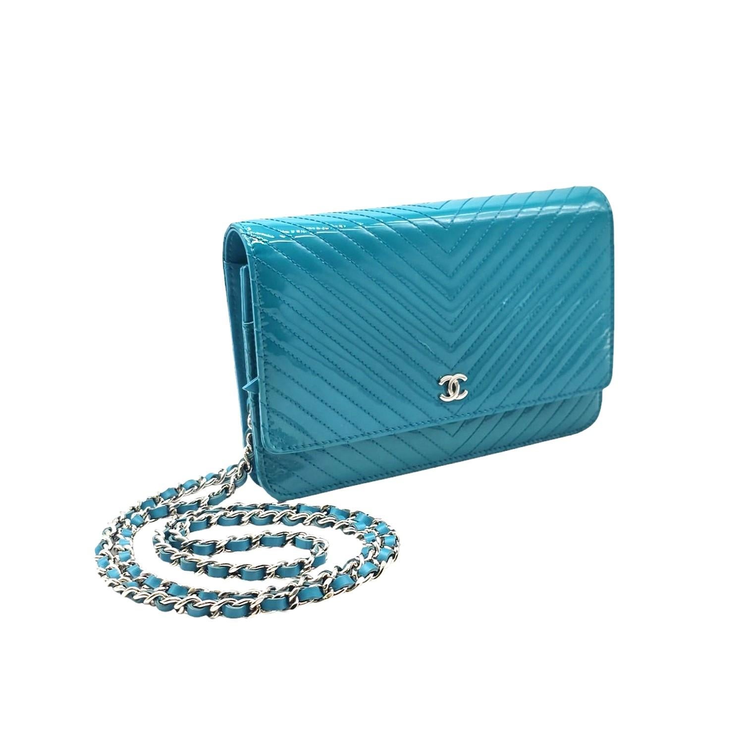 Accessoriati con stile con il portafoglio Chanel Teal Patent Chevron On Chain WOC. Questo portafoglio in vernice è dotato di sei scomparti per le carte di credito, due tasche interne con zip e due tasche esterne e una tasca posteriore esterna per