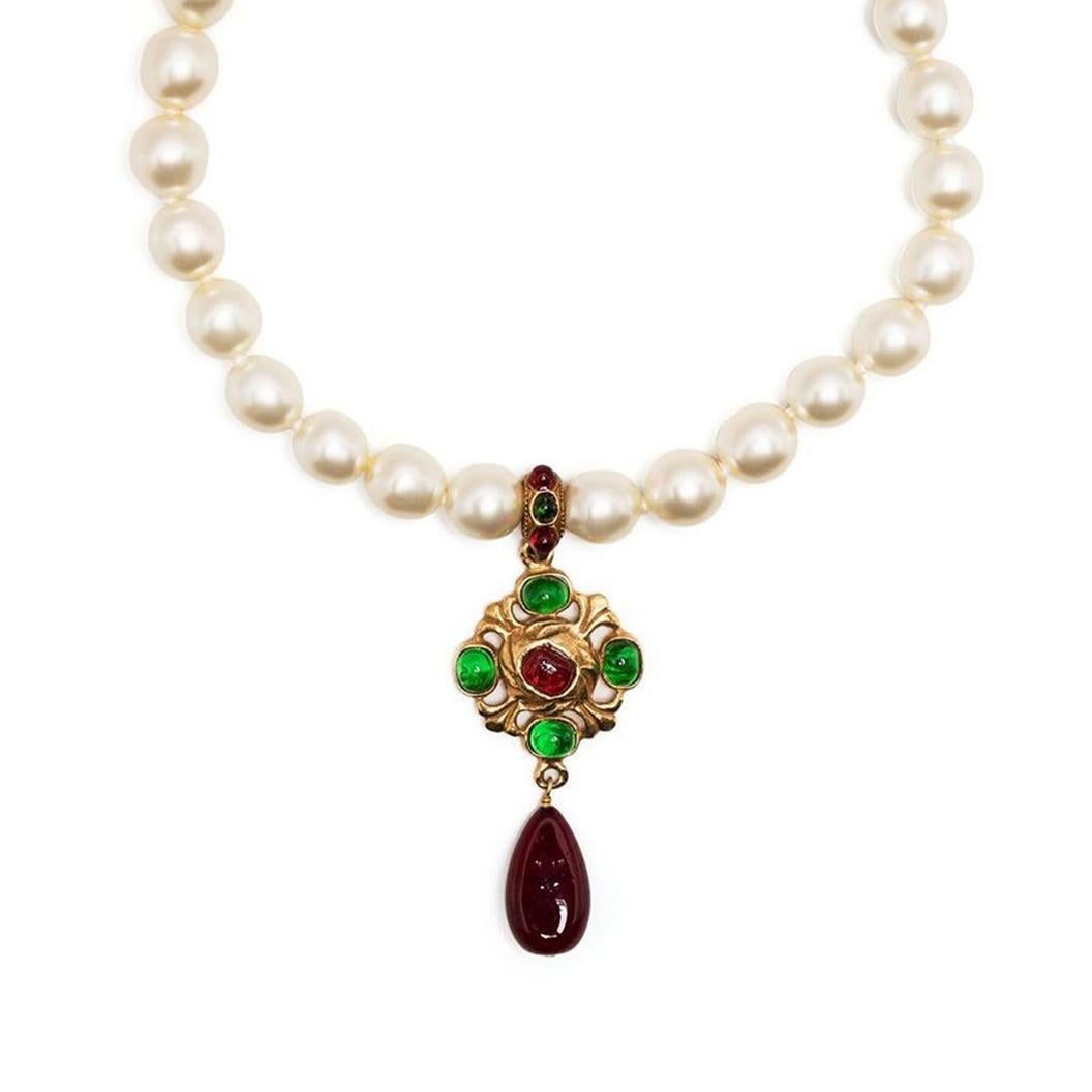 This pre-owned Chanel necklace from 1984 is the epitome of elegance and has all the resemblance of a modern heirloom. Crafted from gold plated metal and strung with faux pearls, this necklace features a round pendant with glass gems embellishment