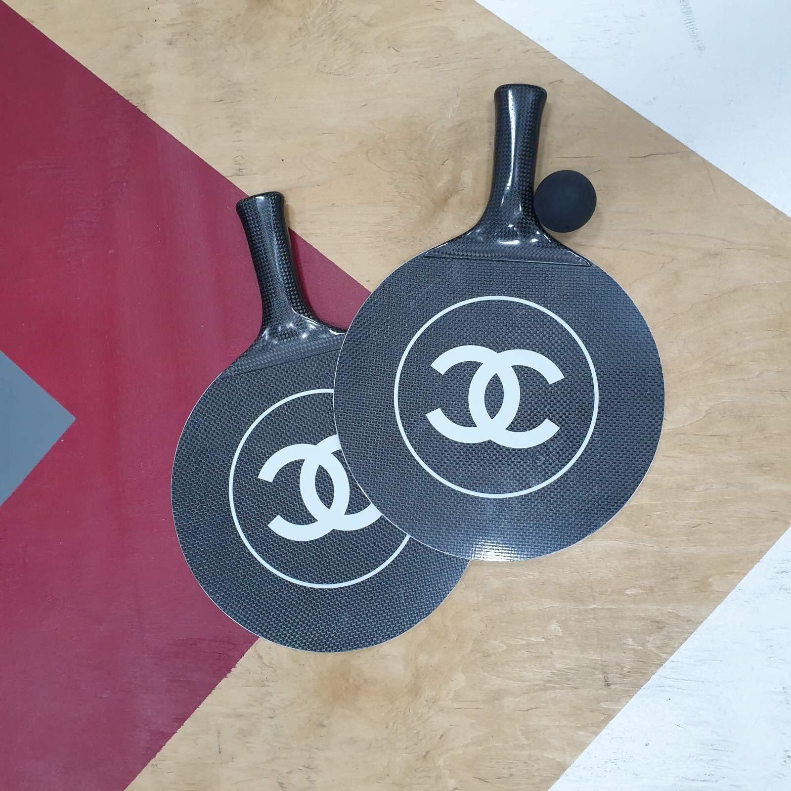 CHANEL Tennis Ping Pong Carbon Fiber Paddles Racket set with rubber ball.

CHANEL Ping Pong/Paddle ball set.

These are such a staple for the luxury connoisseur and an amazing conversation starter!
Stunning CC Iconic Logo.
These rackets are