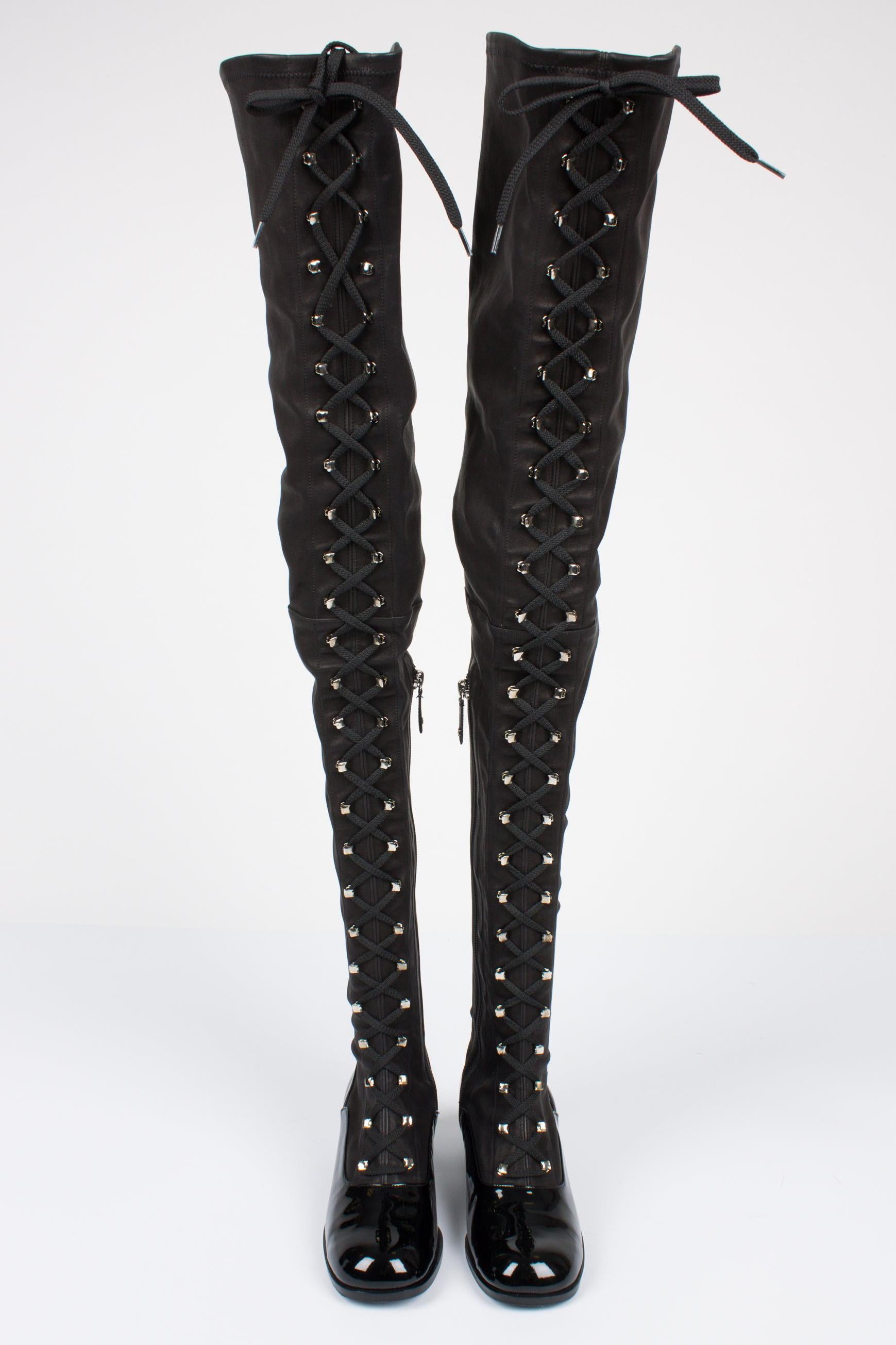 Ultra long lace-up boots by Chanel, true beauties!

This pair is made of stretching leather and patent leather and has an endless row of silver hooks at the front, threaded with a black lace.  Luckily there is a zipper on the side! A small leather