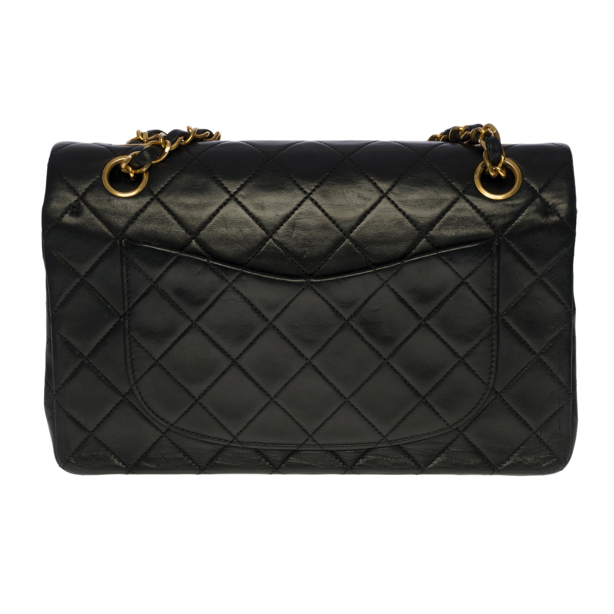 The coveted Chanel Timeless 23cm double flap bag in black quilted leather, gold-tone metal hardware, gold-tone metal chain interlaced with black leather for a shoulder and shoulder strap

Backpack pocket
Flap closure, gold-tone CC clasp
Double