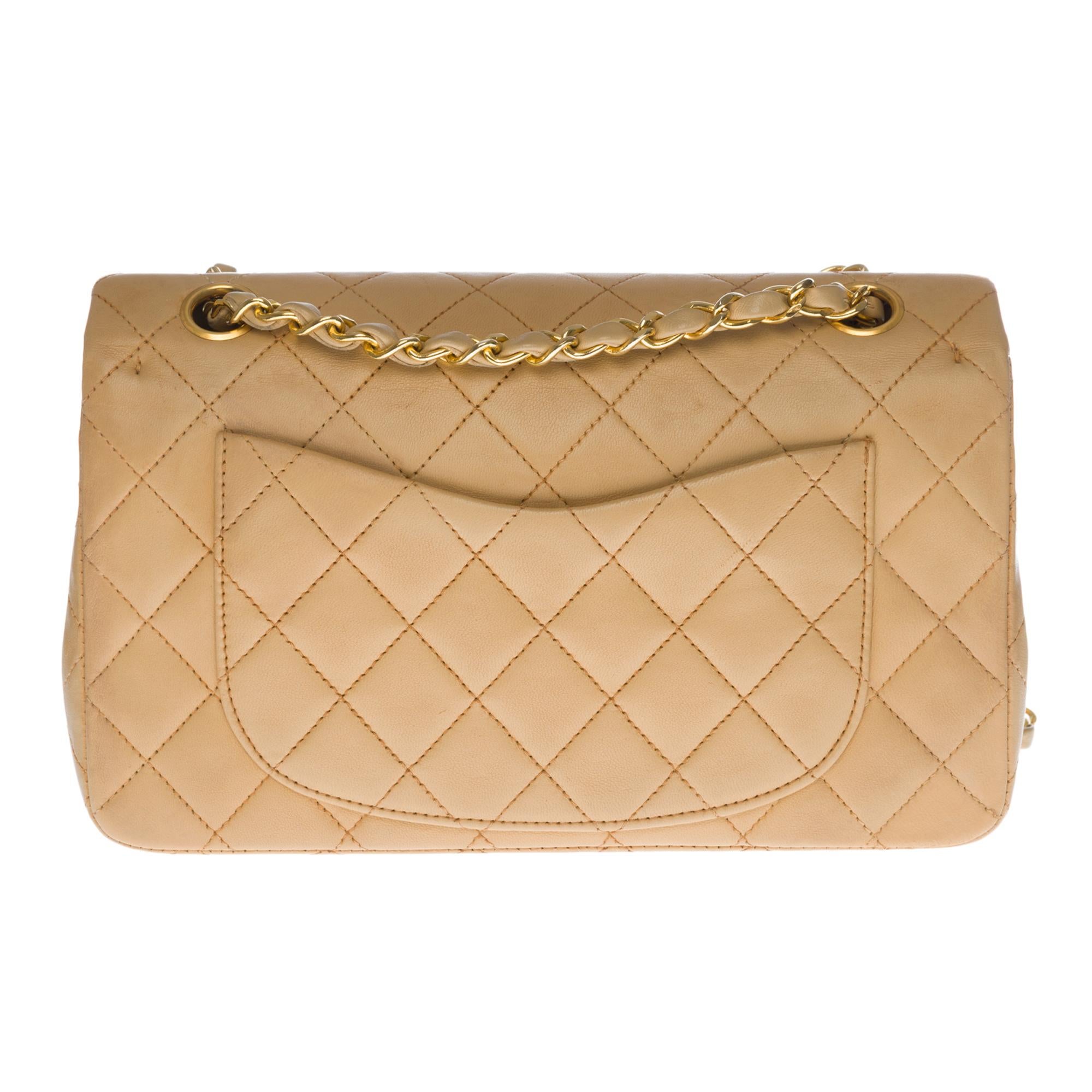 The coveted Chanel Timeless 23cm double flap bag in beige quilted lambskin leather, gold metal hardware, gold metal chain intertwined with beige leather for a shoulder and shoulder strap
Pocket on the back of the bag
Flap closure, gold-tone CC logo