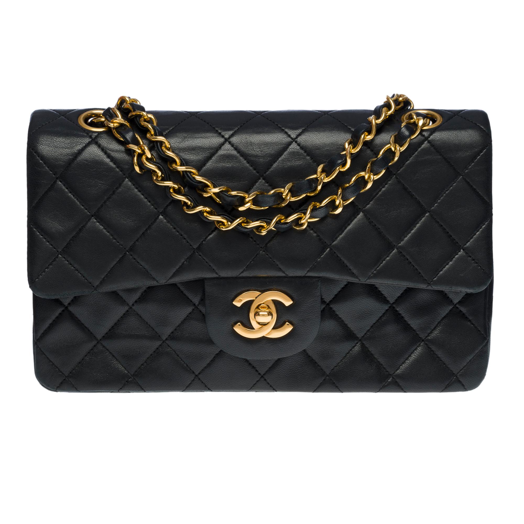 The coveted Chanel Timeless 23 cm double flap shoulder bag in black quilted lambskin leather, gold-tone metal hardware, gold-tone metal chain interlaced with black leather allowing a shoulder and shoulder strap
Backpack pocket
Flap closure, gold CC
