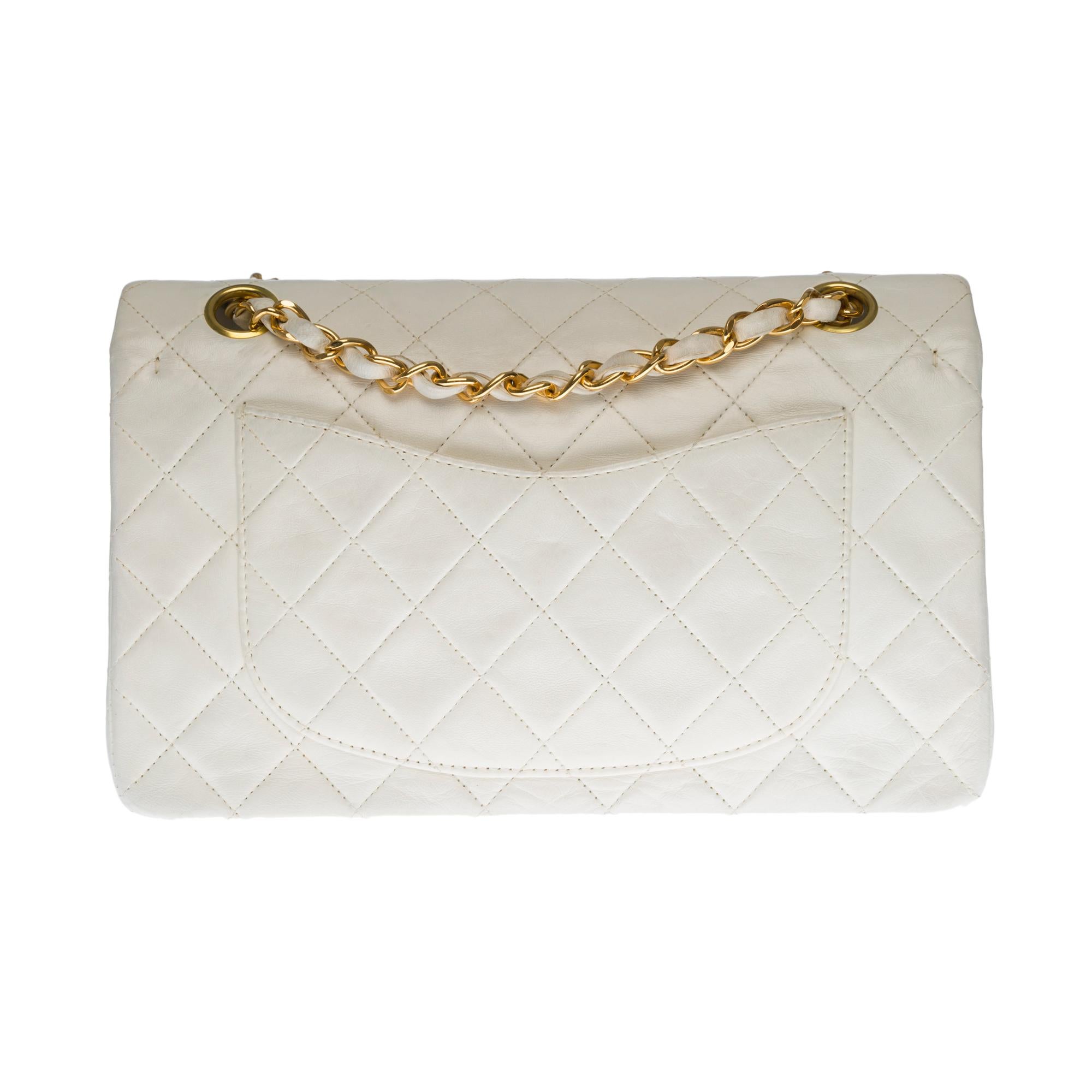 The coveted Chanel Timeless 23cm double flap bag in white quilted lambskin leather, gold metal hardware, gold metal chain intertwined with white leather for a shoulder and shoulder strap
Pocket on the back of the bag
Flap closure, gold-tone CC logo