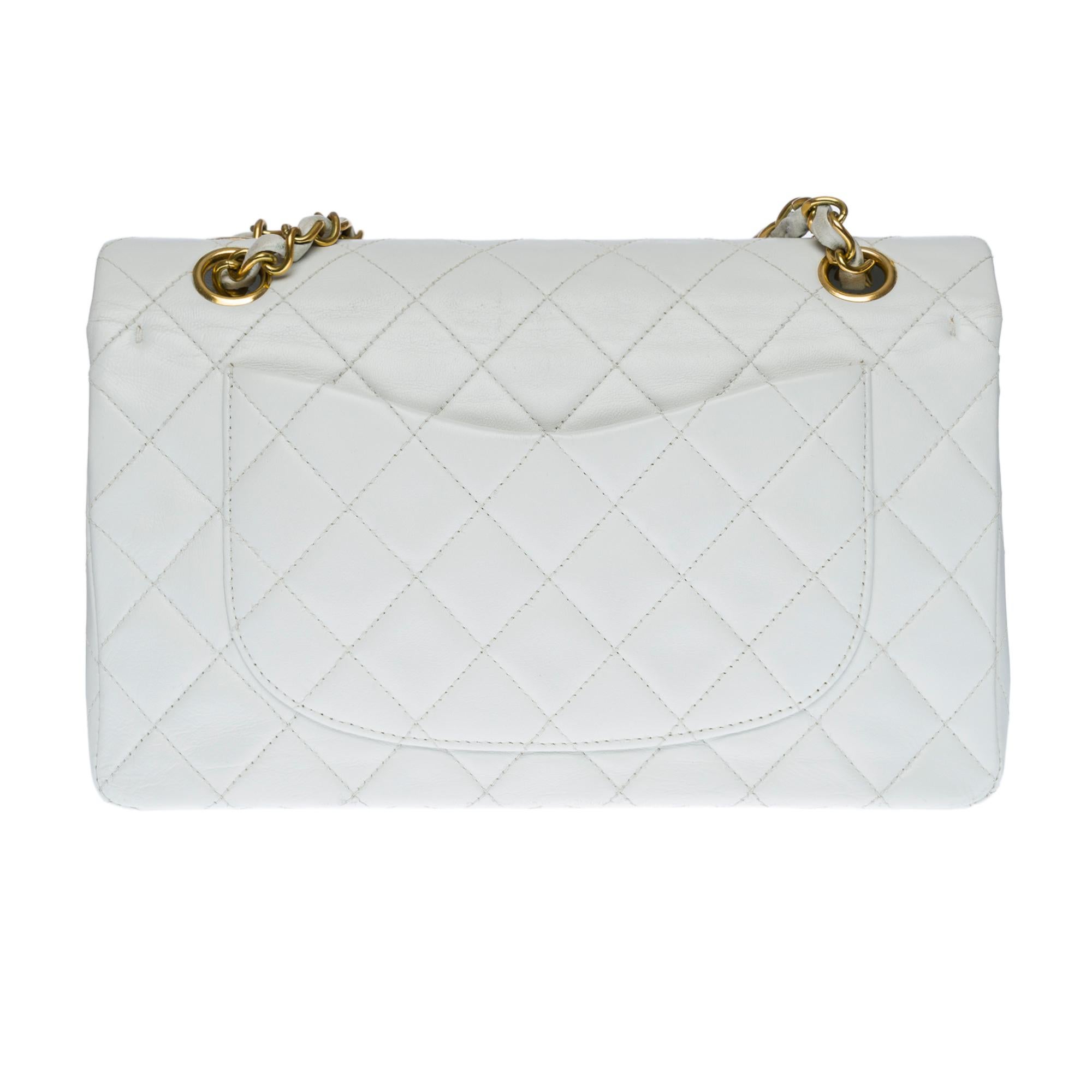 The coveted Chanel Timeless 23cm double flap shoulder bag in white quilted lambskin leather, gold metal hardware, gold metal chain intertwined with white leather for a shoulder and shoulder strap
Pocket on the back of the bag
Flap closure, gold-tone